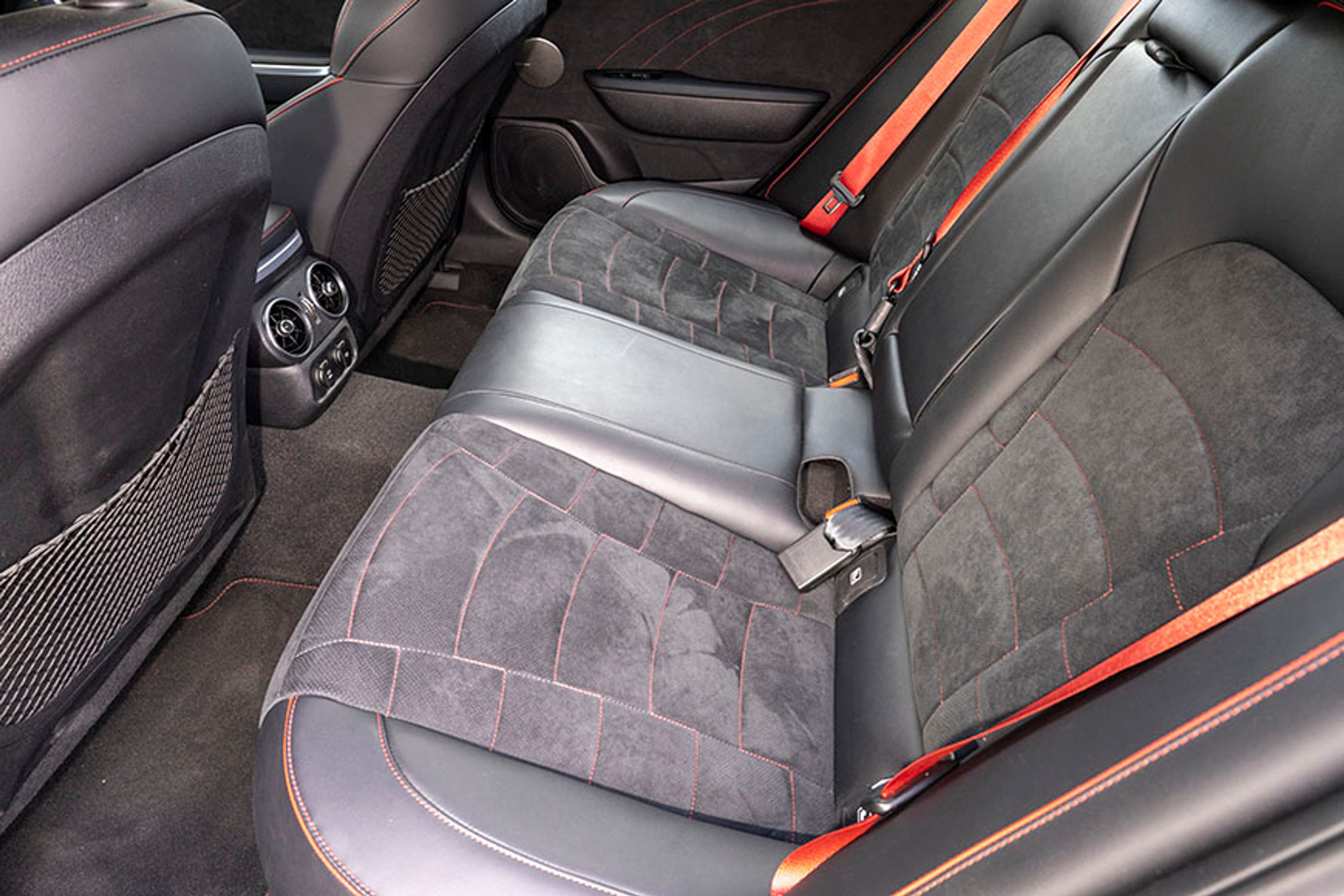 Bagsædet er lækkert med de røde detaljer overalt. Der er tre seler, men kun plads til to voksne, og da skal man ikke være at for høj. Bemærk friskluftdyser mellem forsæderne.