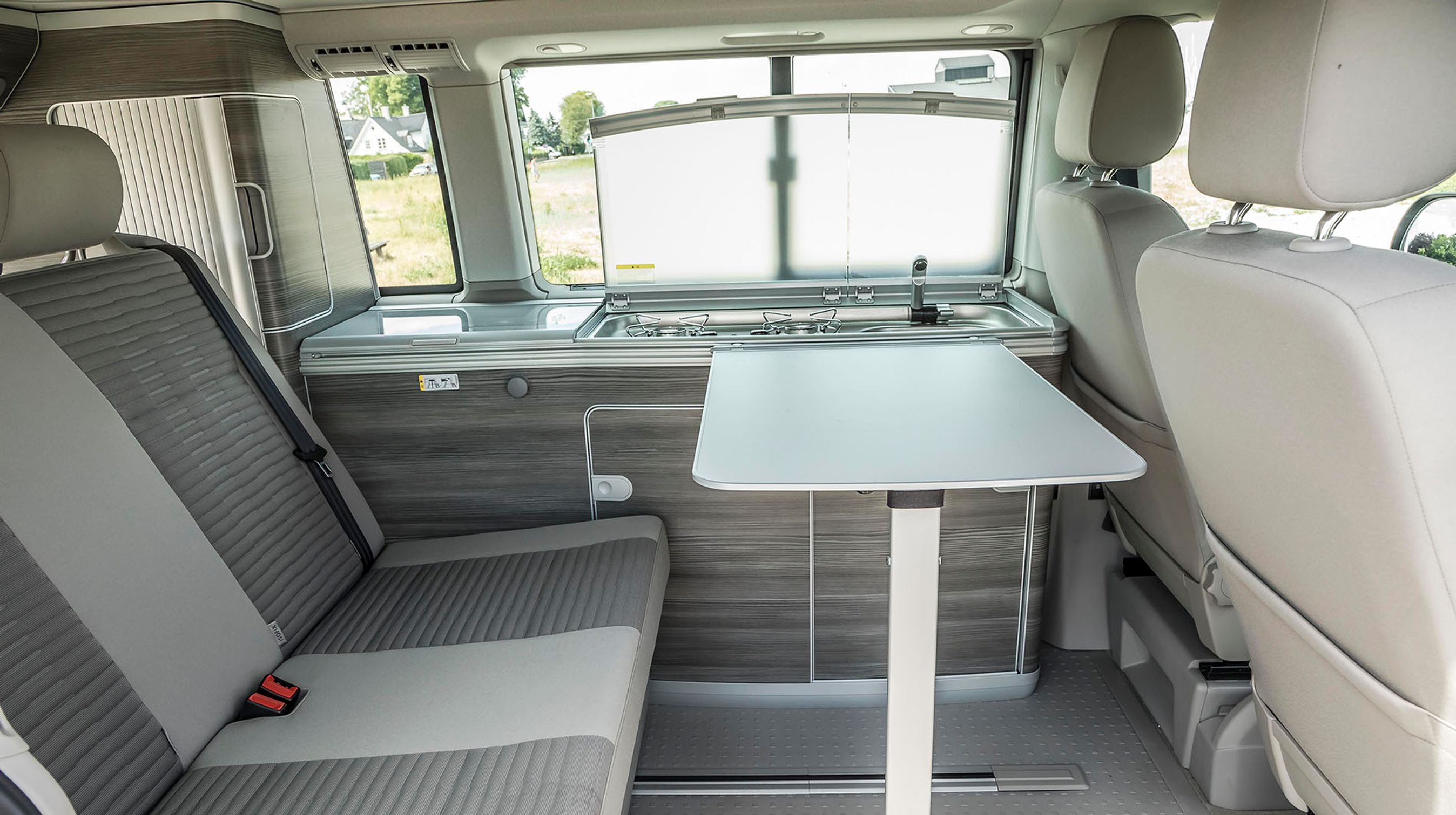 Klapbordet er normalt vippet ned langs skabene, men kan placeres mellem for- og bagsæder ved behov. Når bilen holder stille kan de to forstole drejes rundt, så fire personer kan samles omkring bordet.