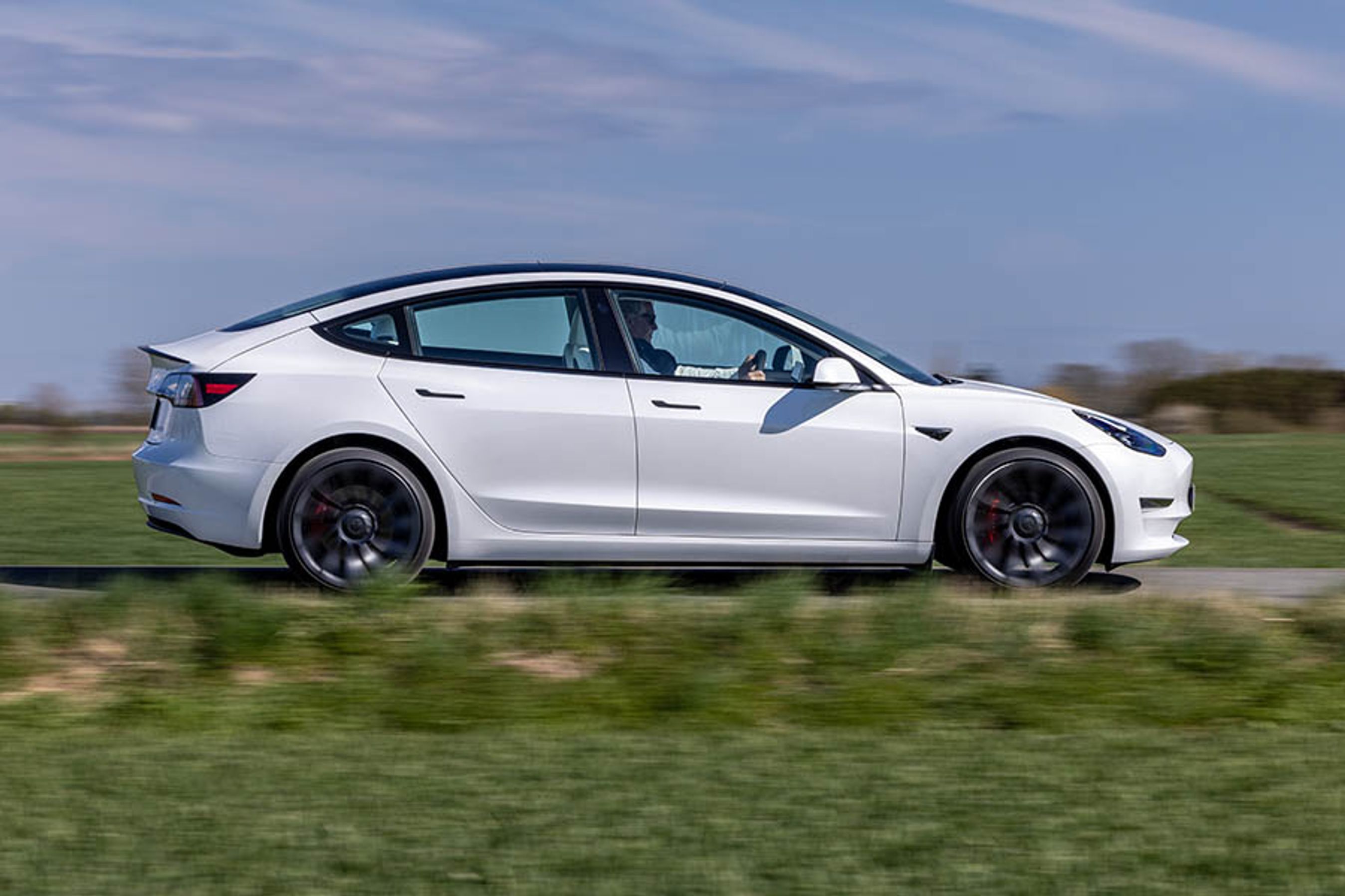 Tesla Model 3 ses fra siden.