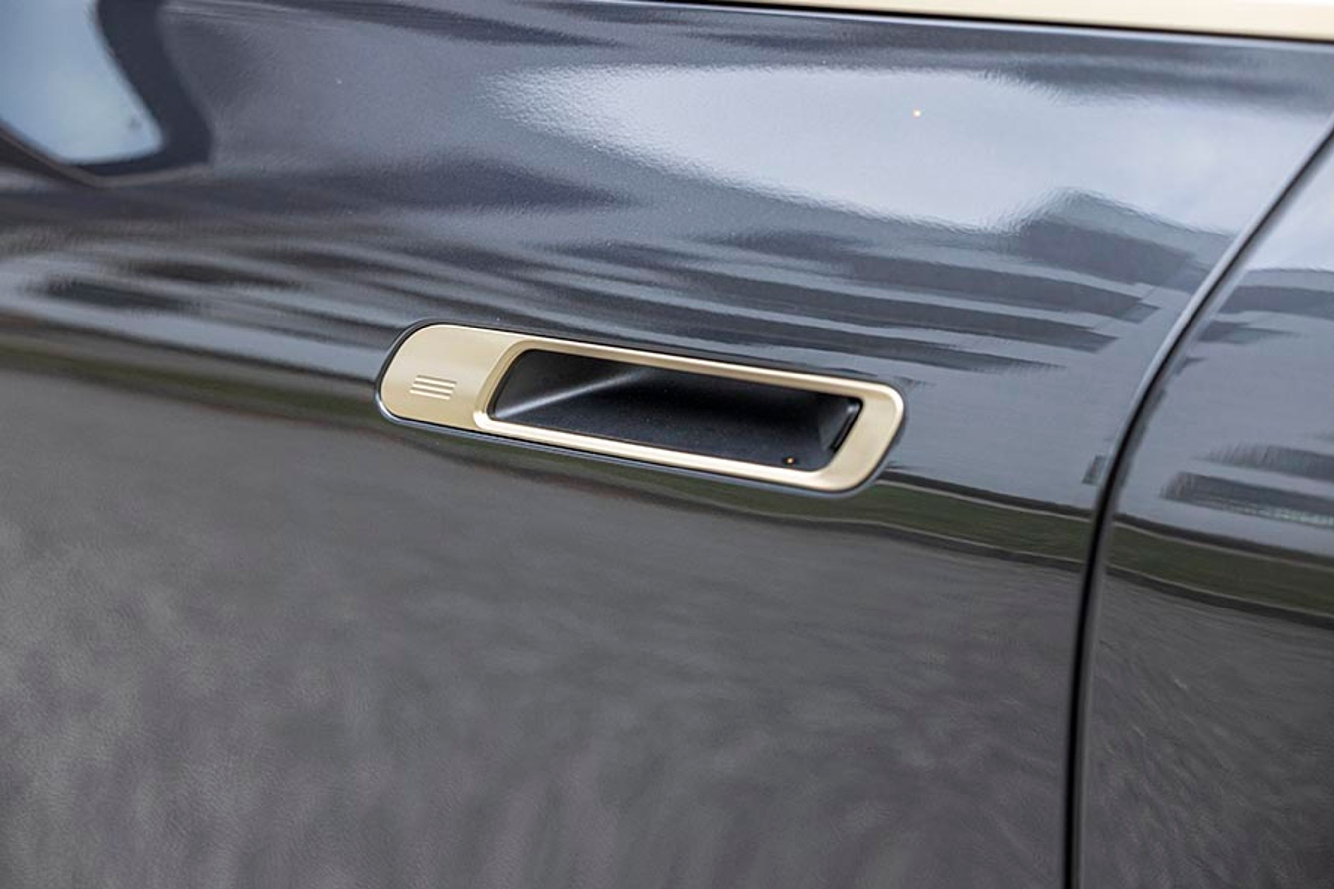 Dørhåndtagene ligger inde i døren, og den rillede form på siden er til at låse bilen. Indvendigt er der en kontakt, så du kan åbne døren.