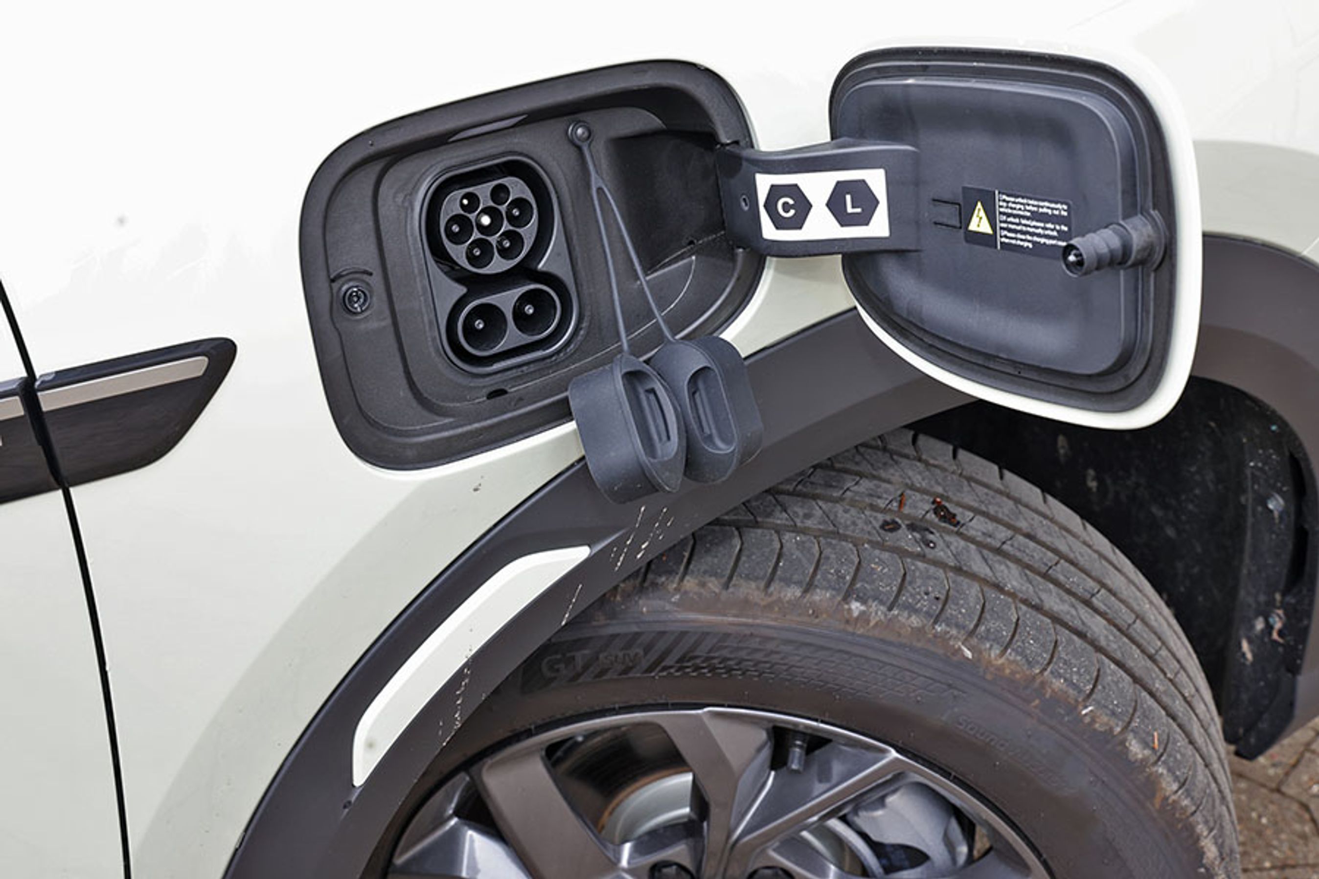 Ladestikket er placeret ved højre forhjul. Der er to gummipropper, som man skal kæmpe med hver gang – det er set bedre i andre biler. Hjemme kan bilen lades med 11 kW (3 faser), og på farten med op til 65 kW. 