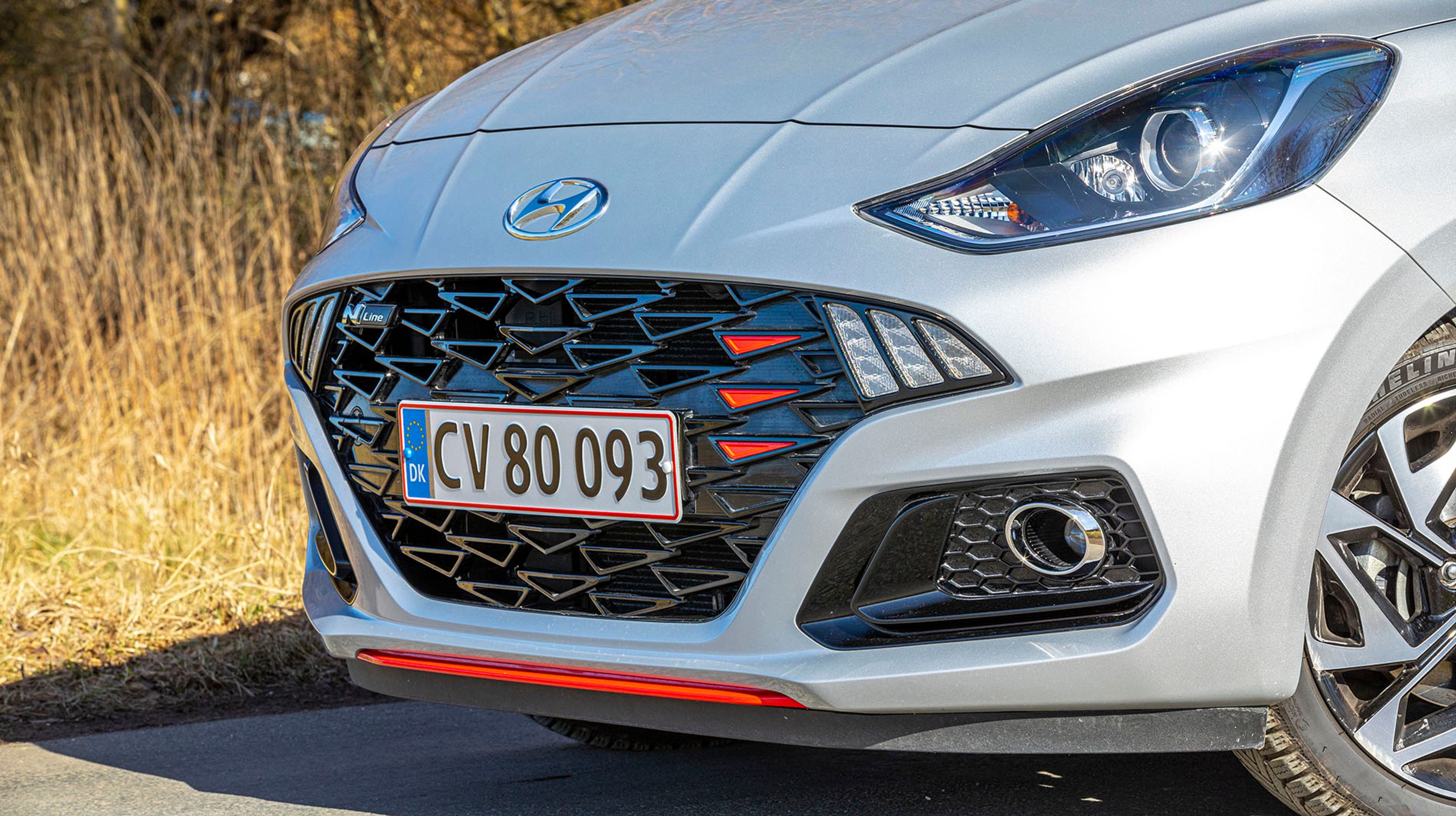 Hyundai i10 N-Line har sin helt egen front, hvor grillen har fået lidt mere aggressivt udseende, og de runde kørelys-lygter er erstattet af tre skråtstillede LED-lamper. Røde detaljer inde og ude giver bilen et GTI-look.