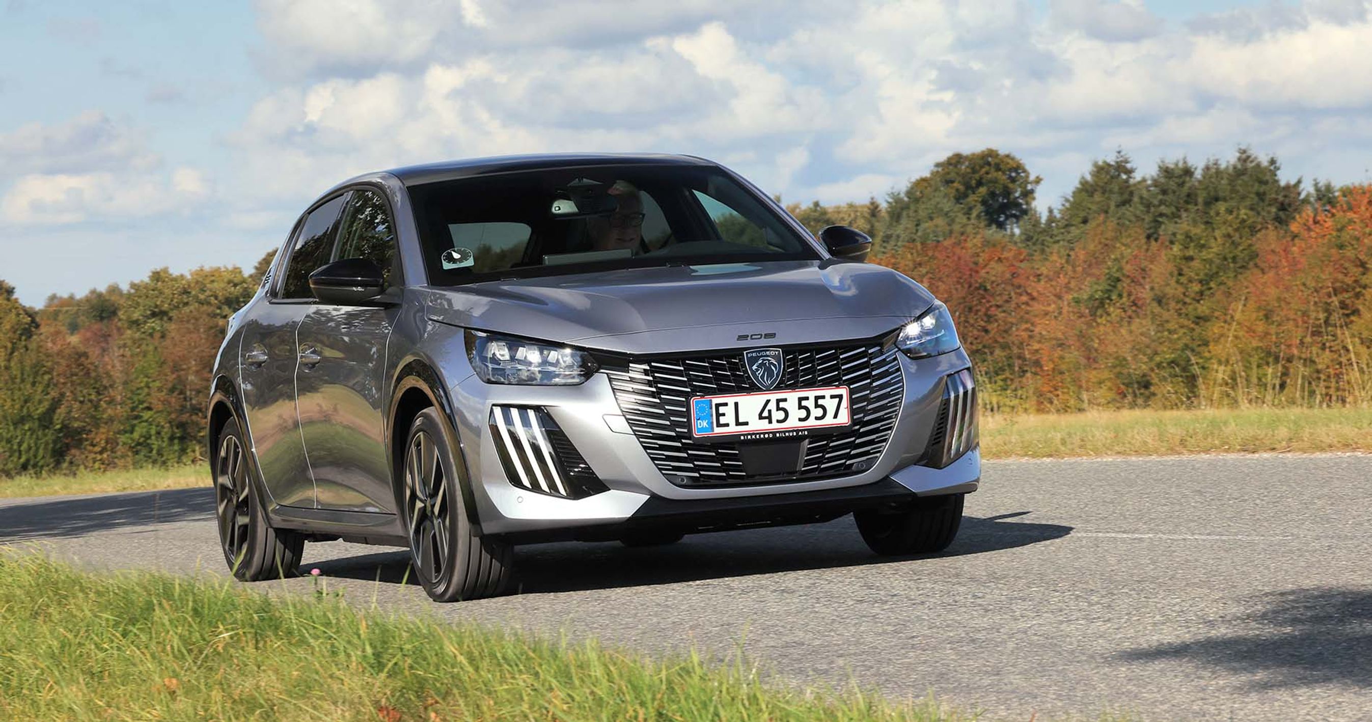 Peugeot E-208 set forfra, mens den kører på en landevej