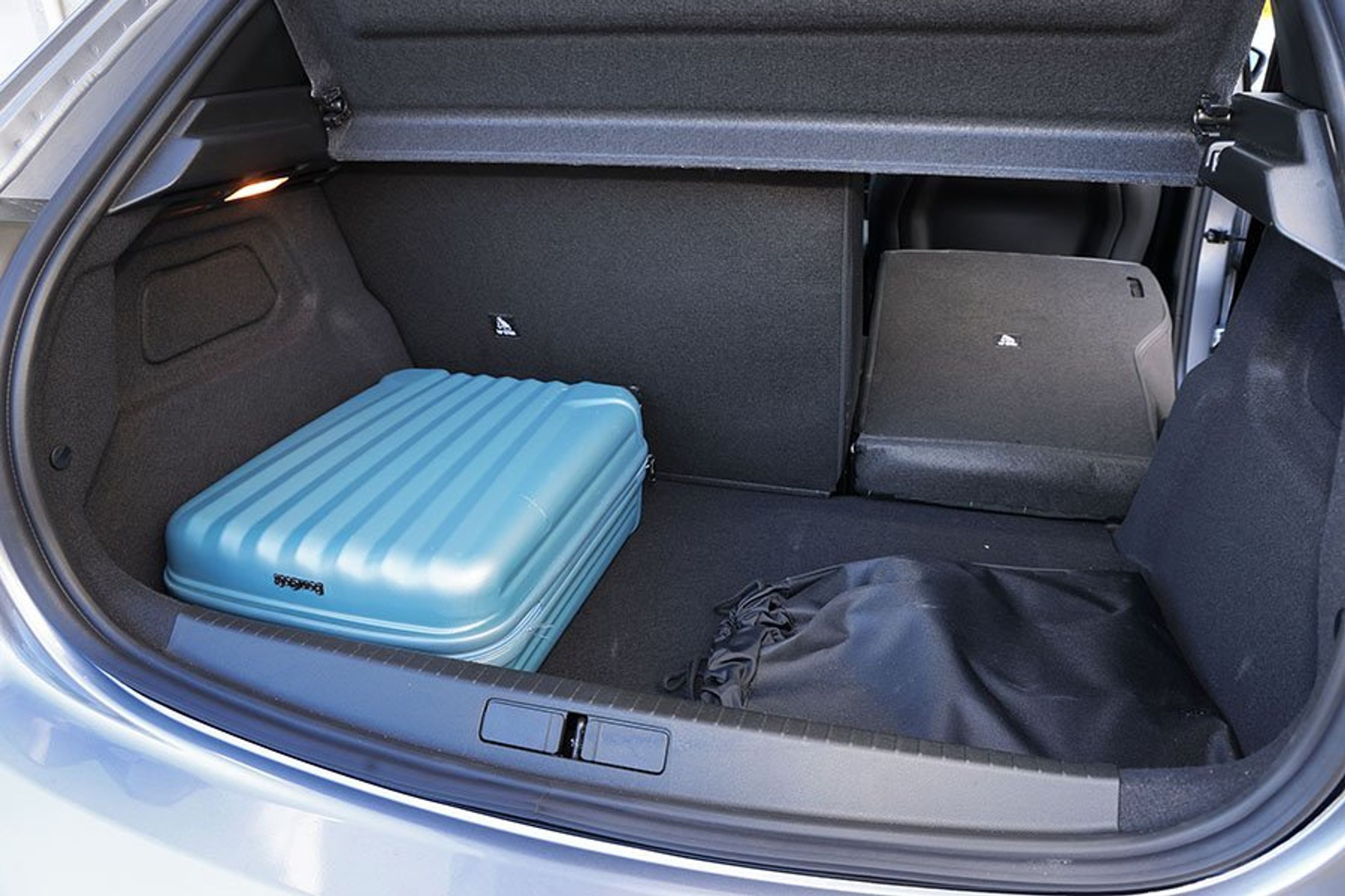 Bagagerum med blå kuffert i en Peugeot E-208