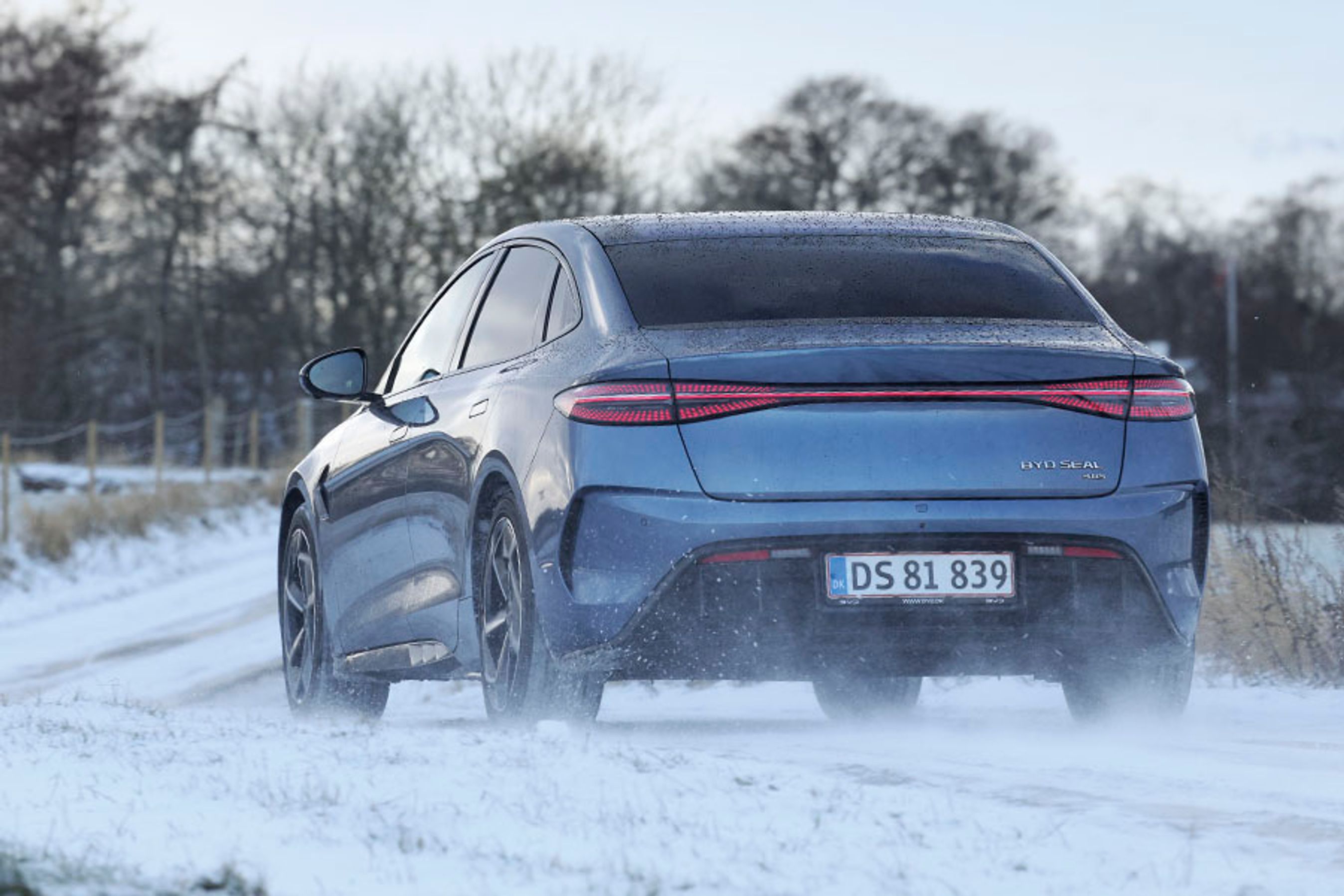 BYD Seal set bagfra, mens den kører på en snedækket landevej