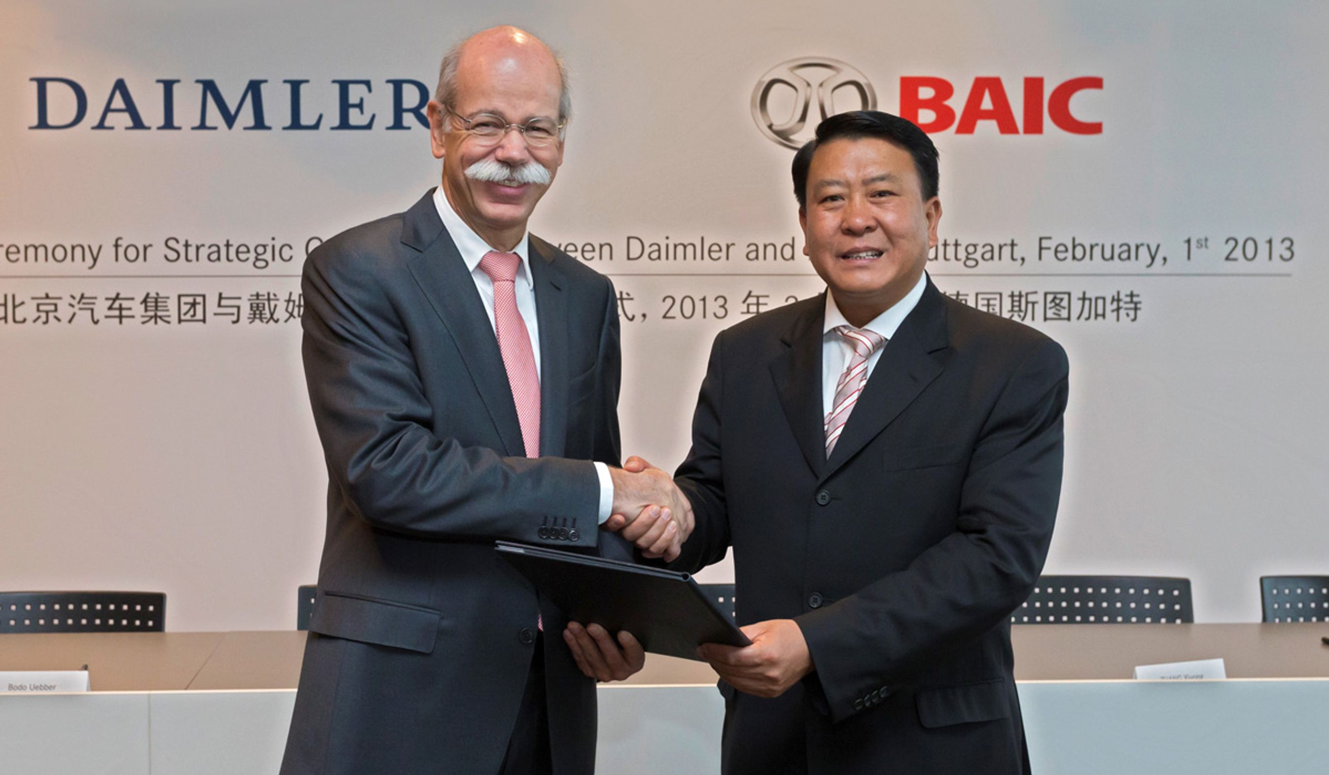 Daimlers topchef Dieter Zetsche giver BAICs formand Xu Heyi hånden på handlen. 
