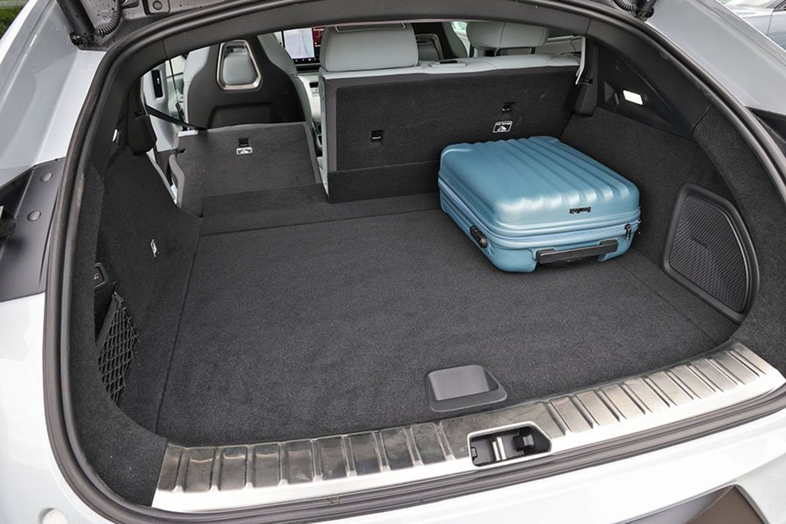 Bagagerum med blå kuffert i en Polestar 4.