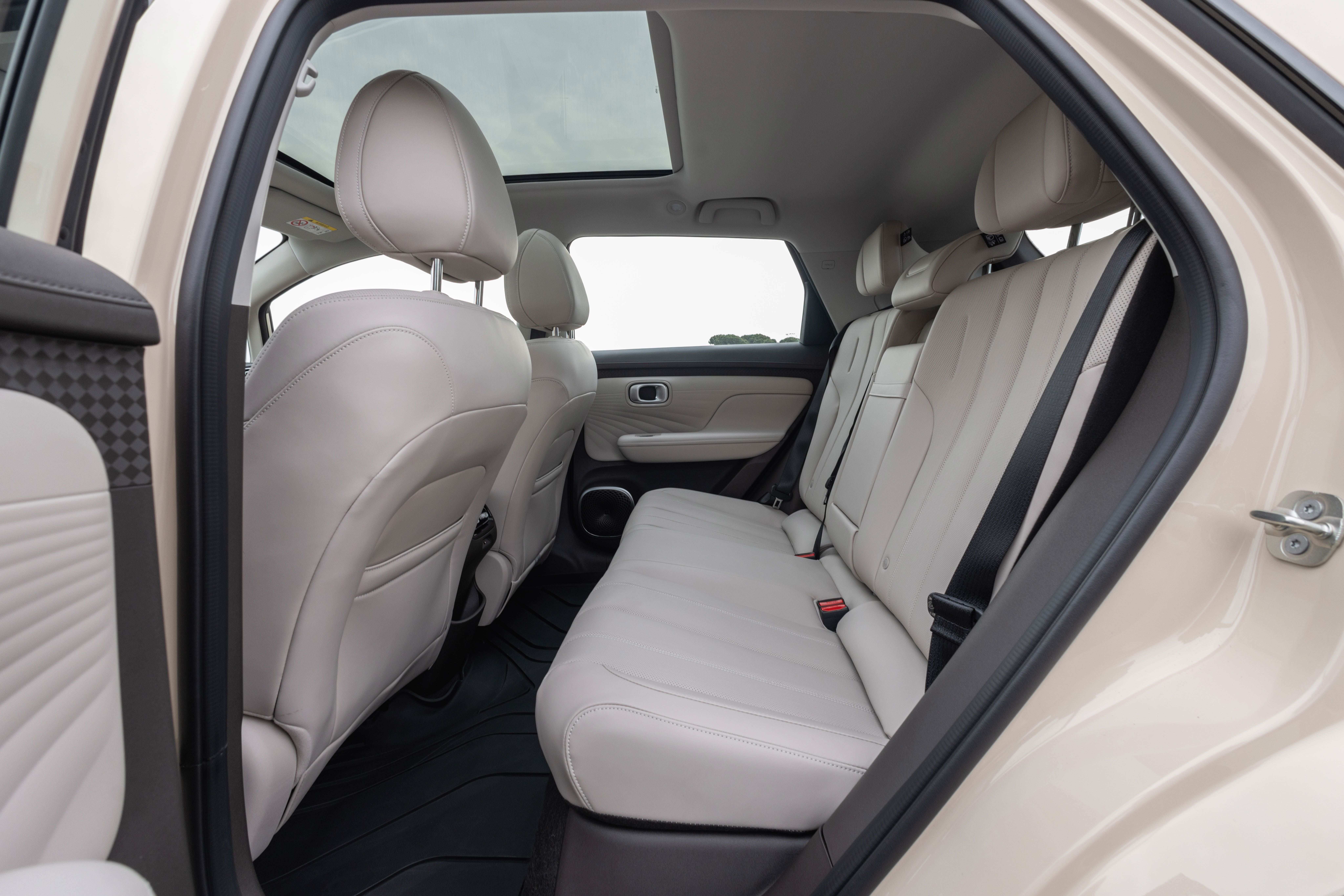 Bagsædet på en Aion UT. Sæderne er hvide og der er et glastag. 