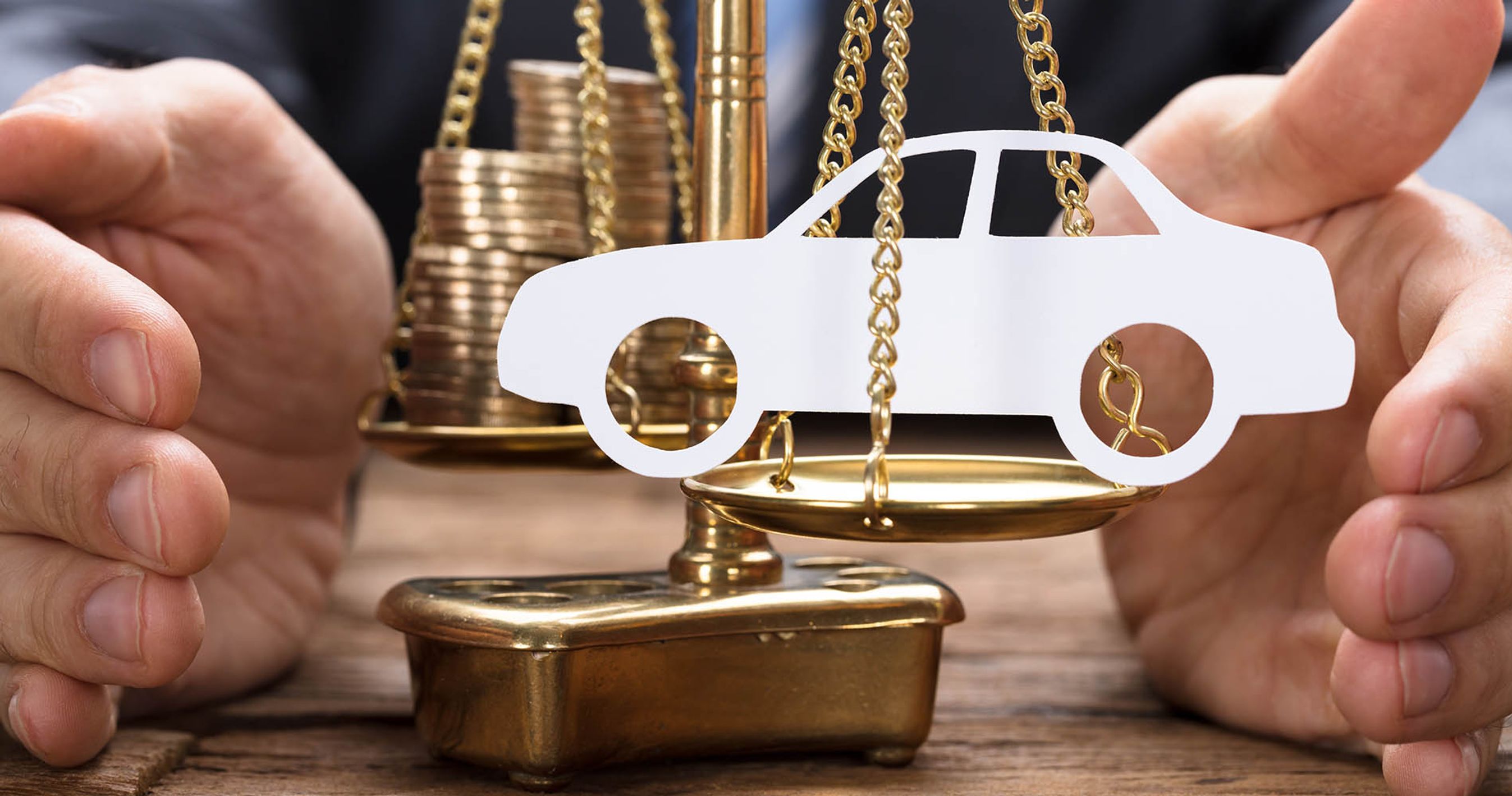 En vægt, hvor der på den ene side er penge og på den anden side er en bil.