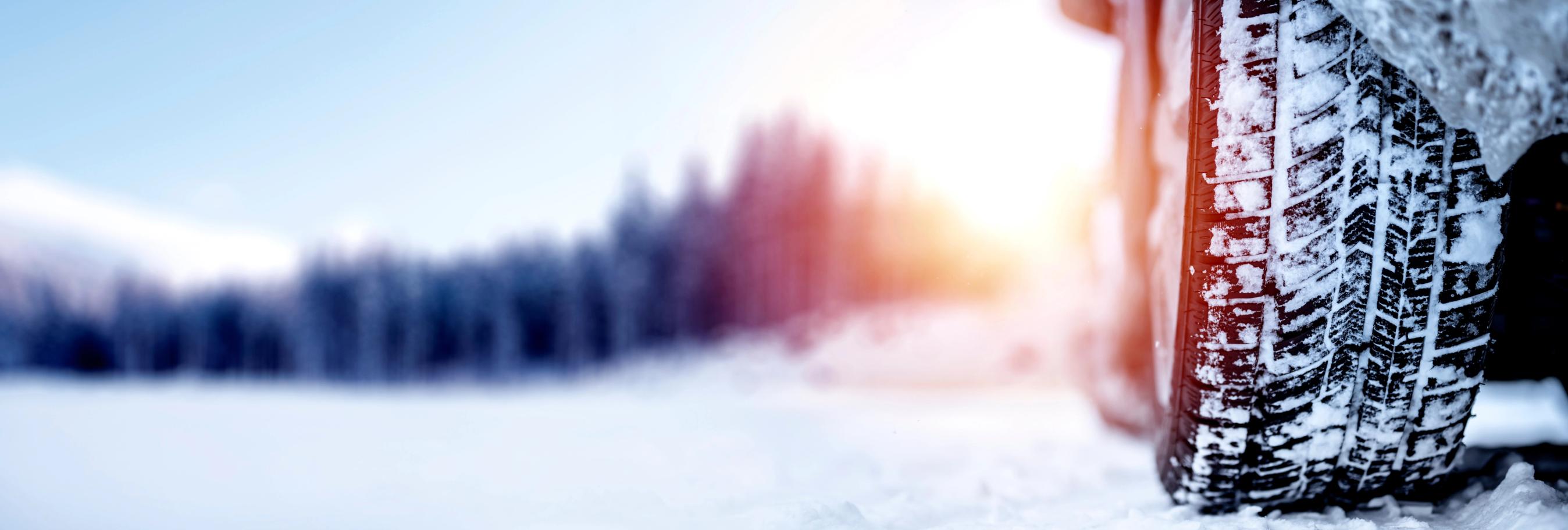 Nærbillede af dæk på bil med sne på i vinterligt vejr