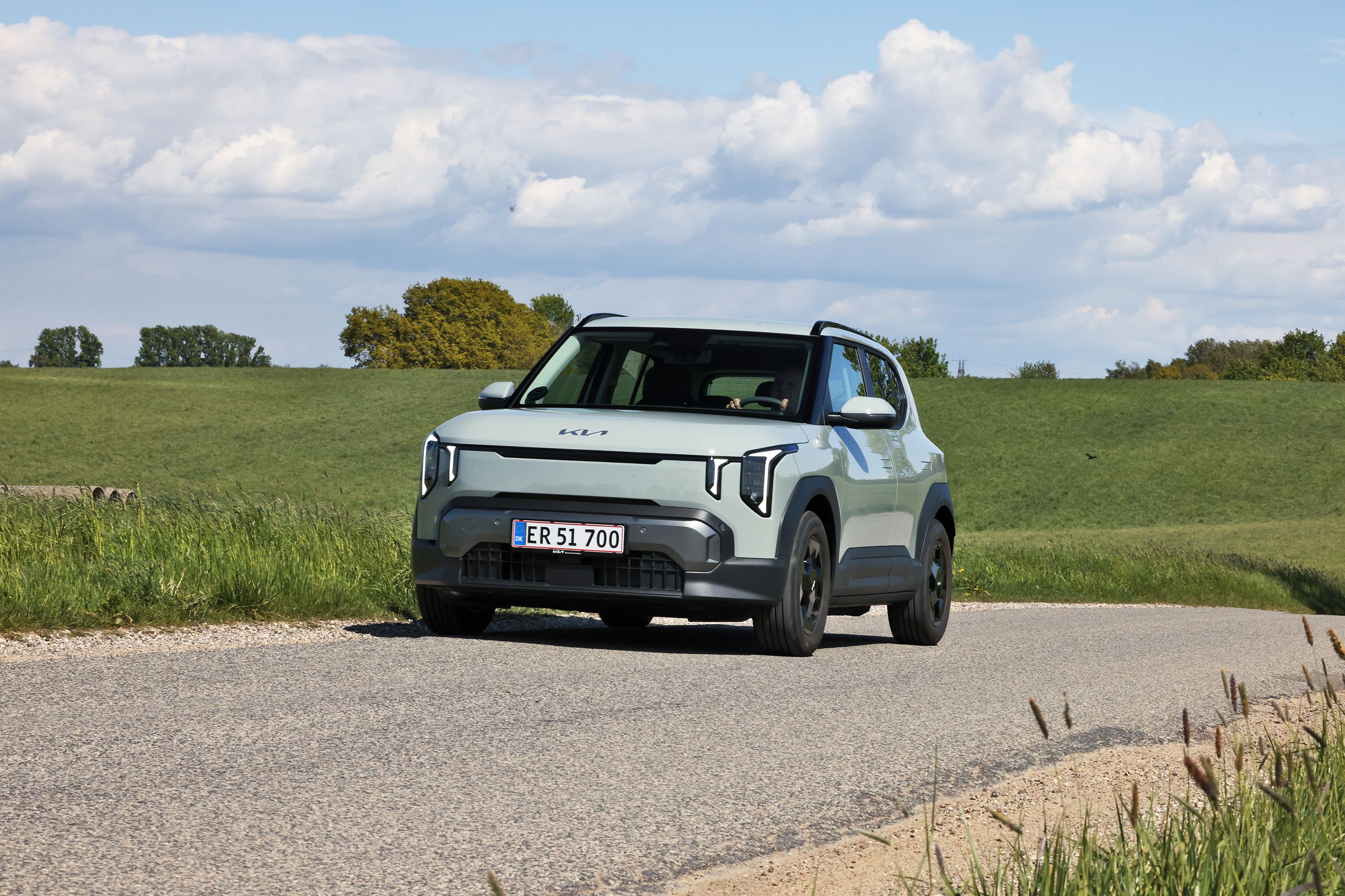 Kia EV2 set skråt forfra, mens den kører på en landevej