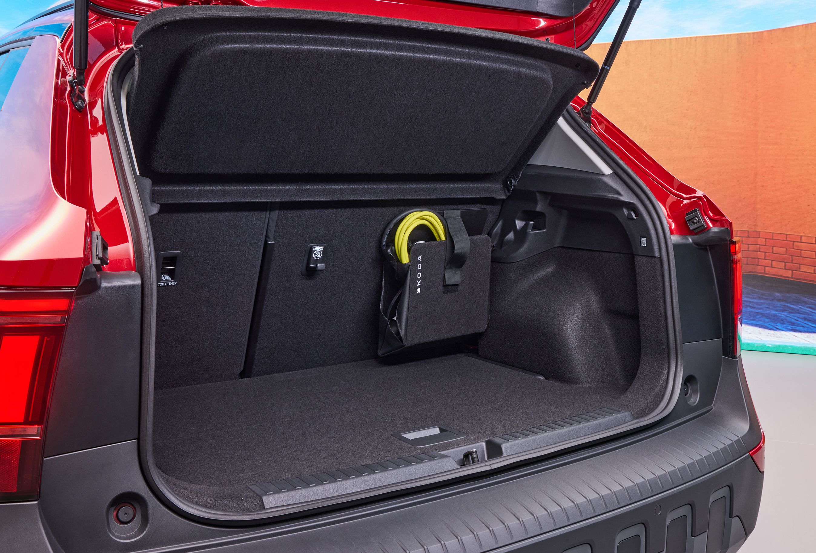 Bagagerum i Skoda Epiq med holder til gult ladekabel.