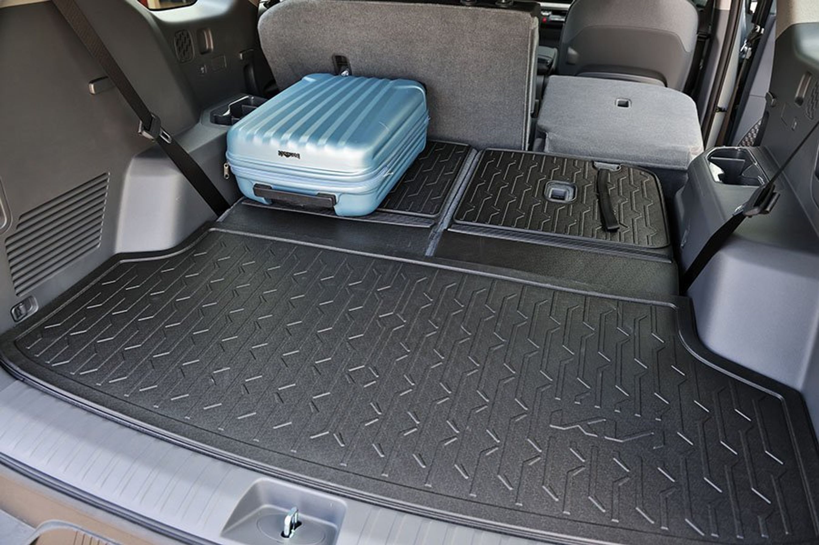 Stor bagagerum med blå kuffert i en KIa EV9