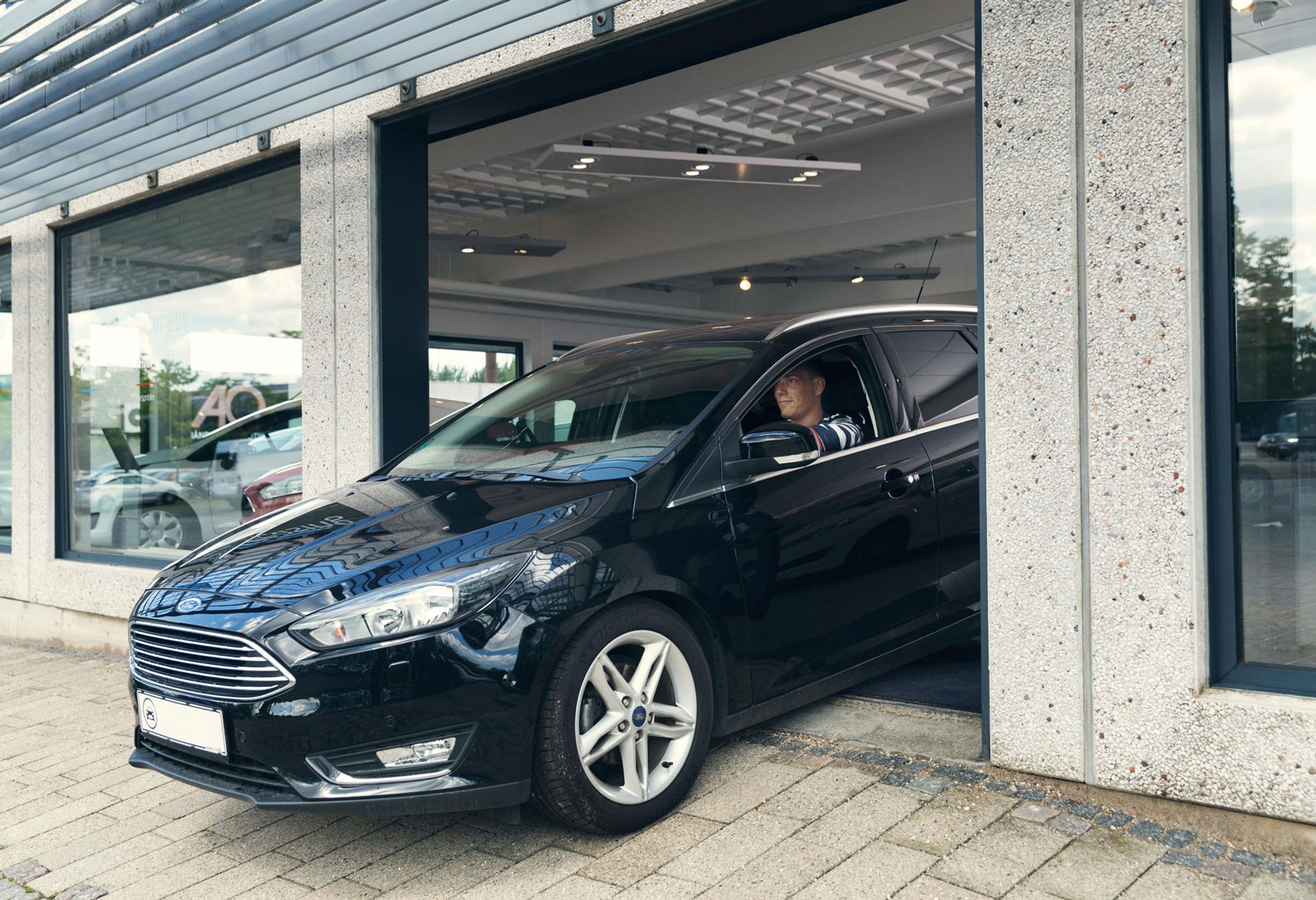 Bil kører ud fra bilforhandler