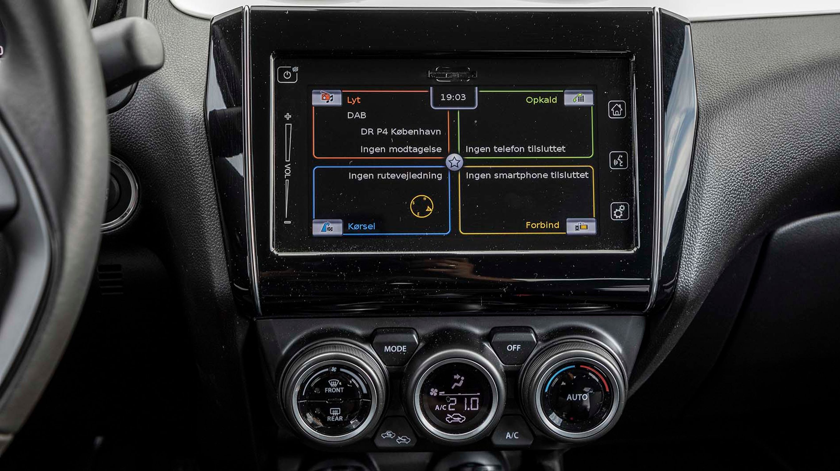 Suzukis „multimediecenter“ indeholder DAB+ radio, Apple CarPlay og Android Auto foruden bakkamera og navigationsanlæg. Den standardmonterede 7”-skærm er dog svær at se i solskin og noget langsom til at skifte mellem skærmfunktioner. Alle menuer er på dansk, og der er dansk tale. Vi savner en drejeknap til lydniveauet, der dog kan styres fra rattet.