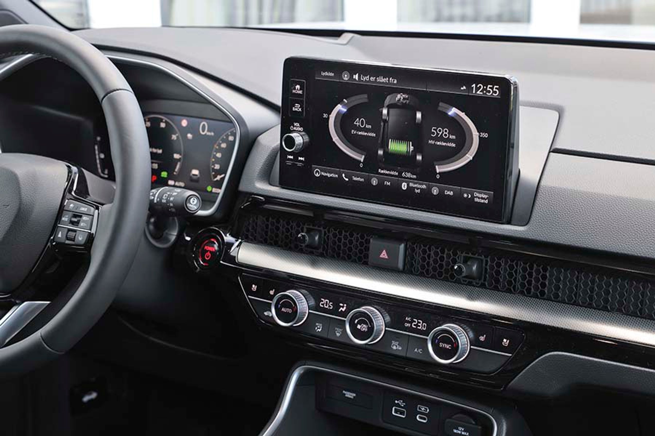Der er store drejeknapper til klimaanlægget, og øverst i midten er den store opretstående skærm, hvorfra man bl.a. kan følge med i, hvordan strømmen løber mellem batteri og elmotor.