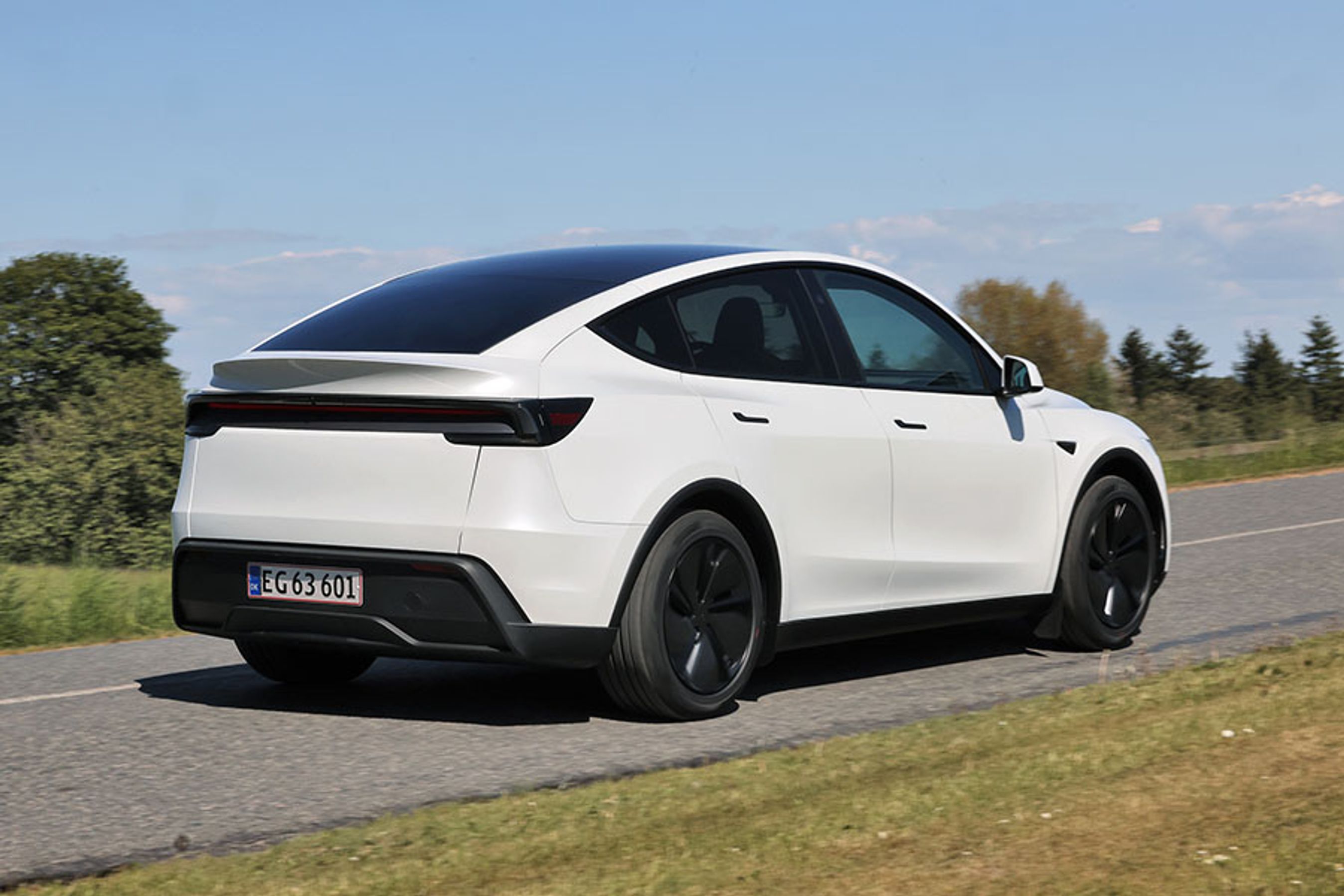 Tesla Model Y set bagfra, mens den kører på en vej