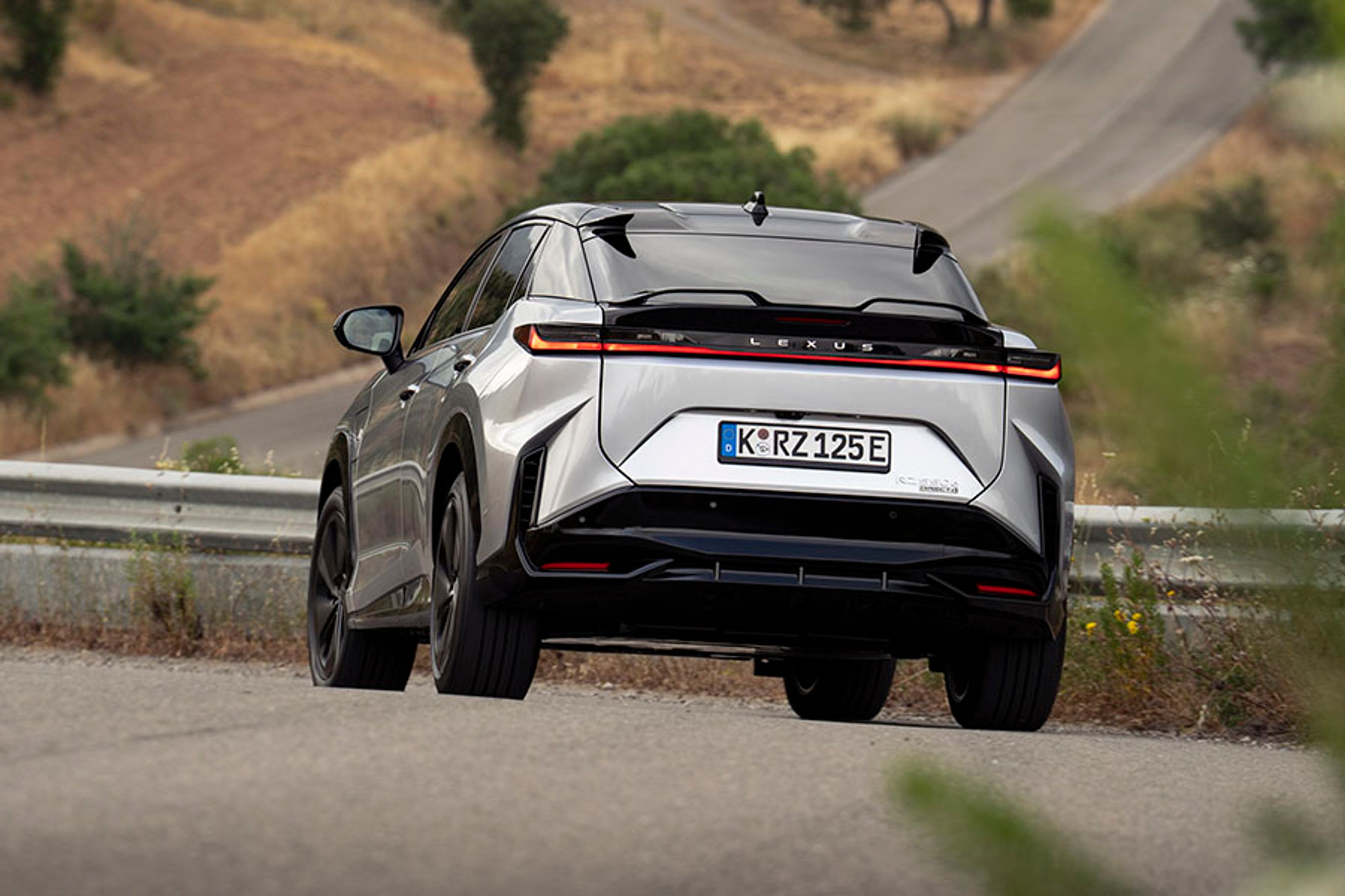 Lexus RZ set bagfra, mens den kører på en vej