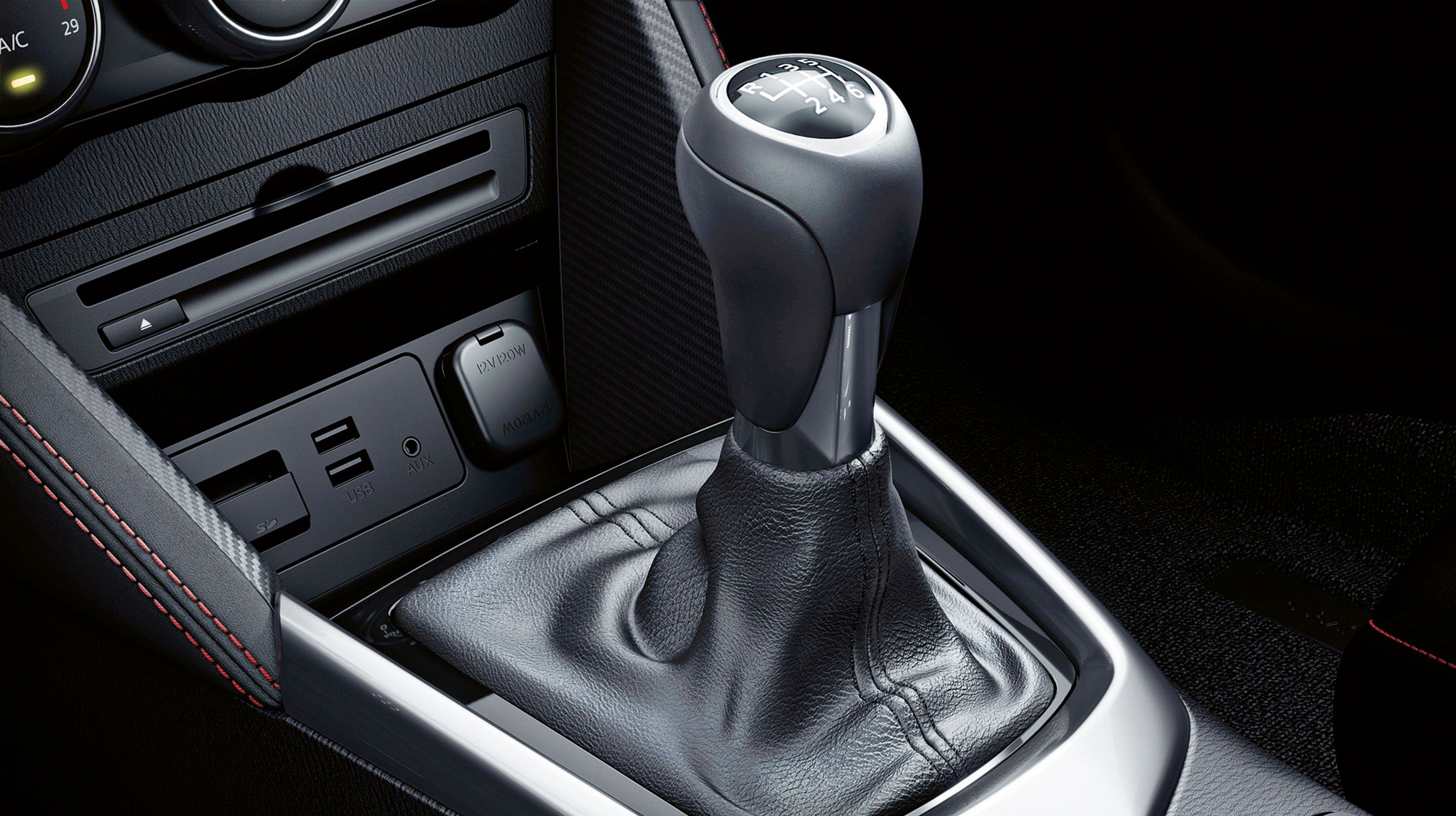Foran gearstangen er der to USB-stik, 12V-udtag samt en kortlæser til navigationsanlægget. Der er også fin plads til en mobiltelefon.