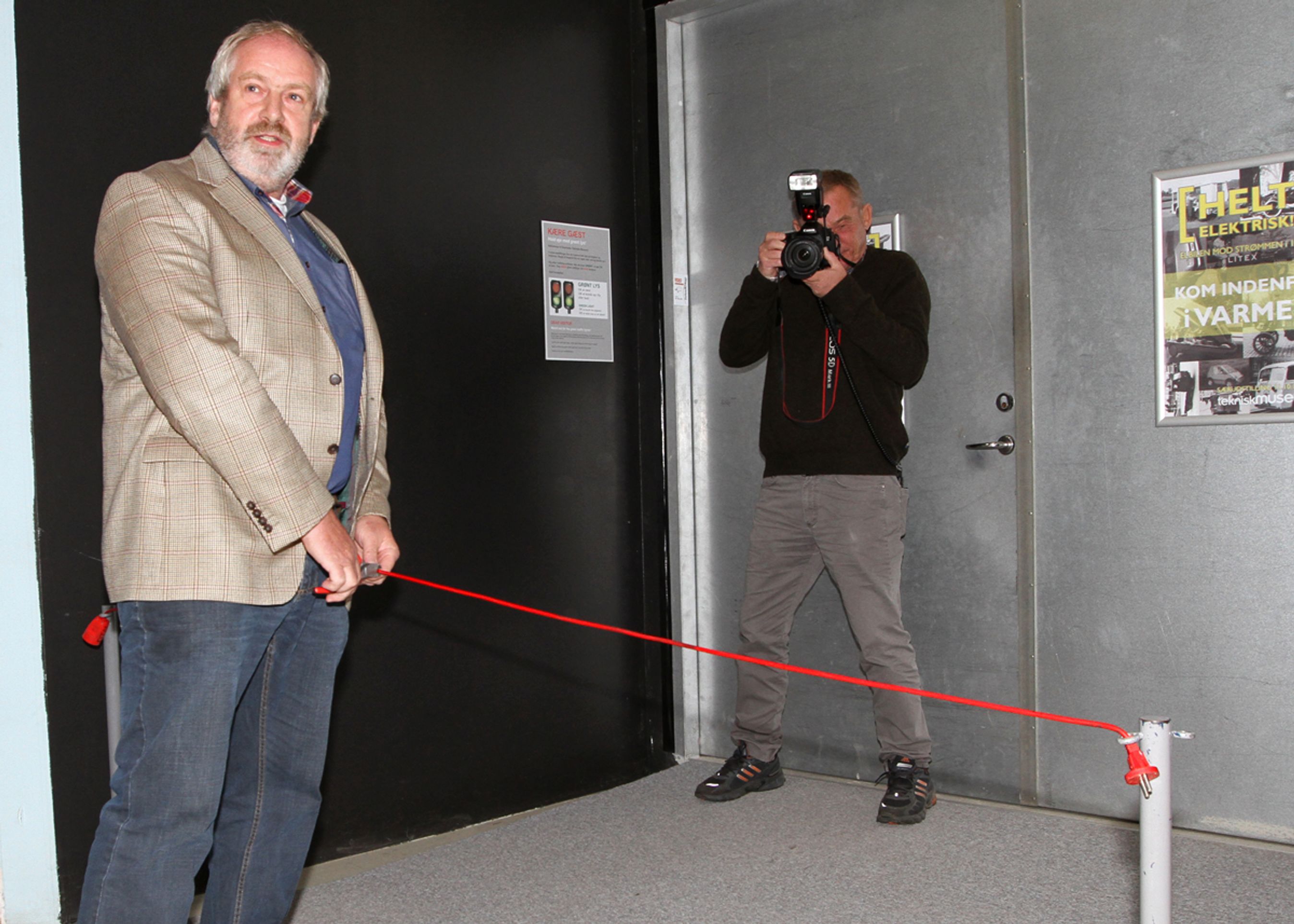 Elbilveteranen Henning Bitsch åbner udstillingen på Danmarks Tekniske Museum ved at klippe en elledning over med bidetang.