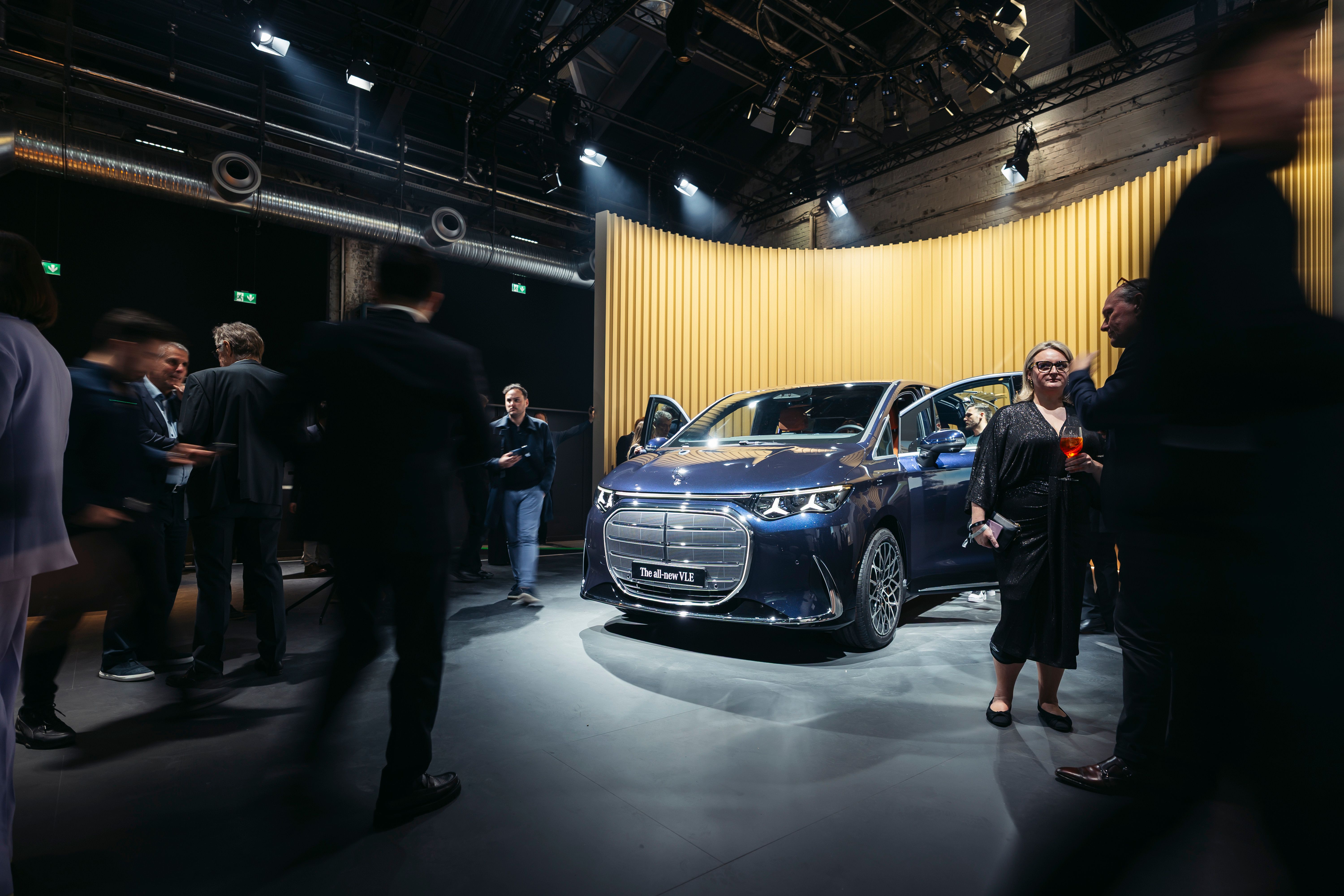 Præsentation af bilen Mercedes-Benz VLE, der står på et podie med mennesker rundt om