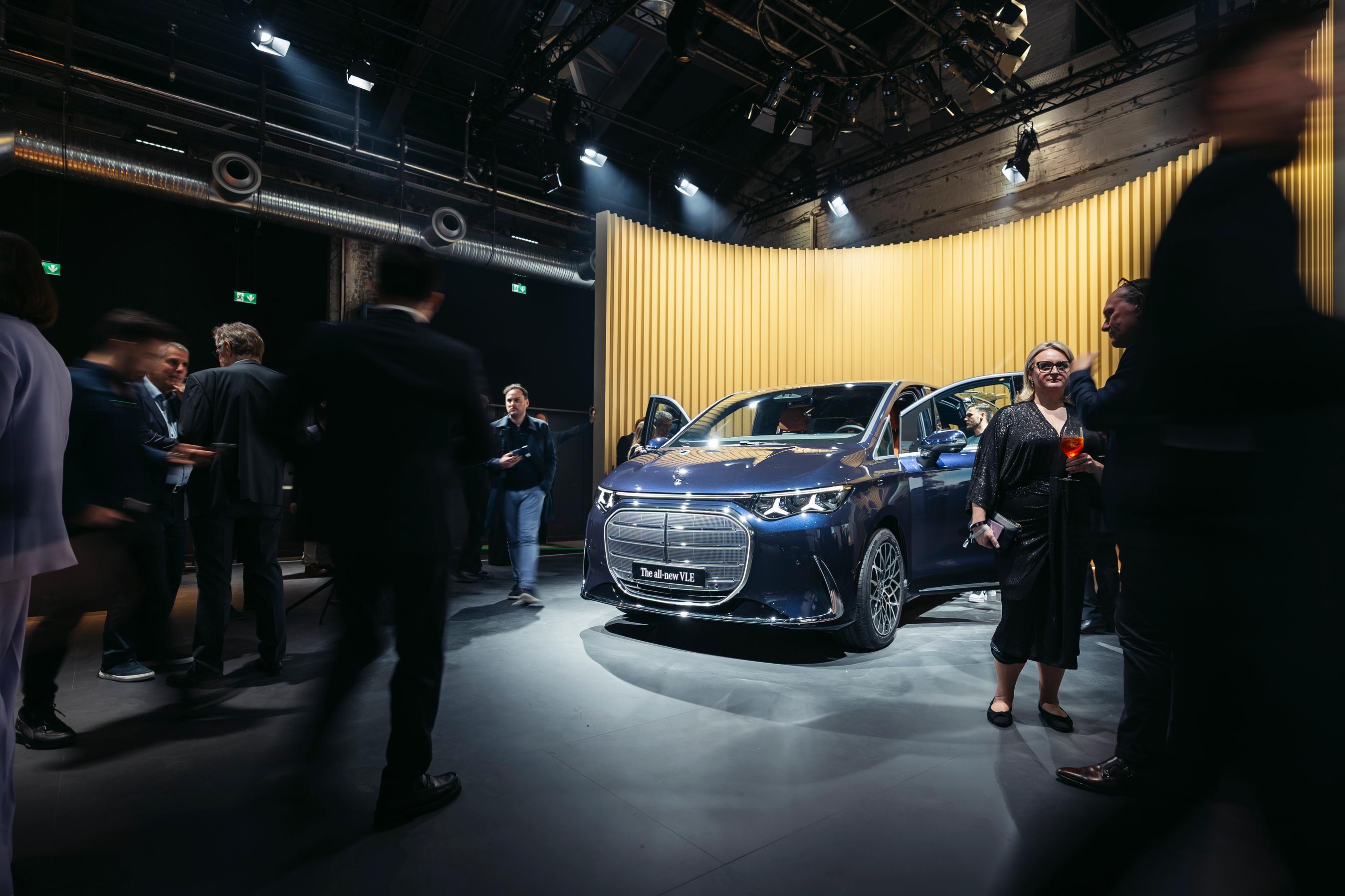 Præsentation af bilen Mercedes-Benz VLE, der står på et podie med mennesker rundt om