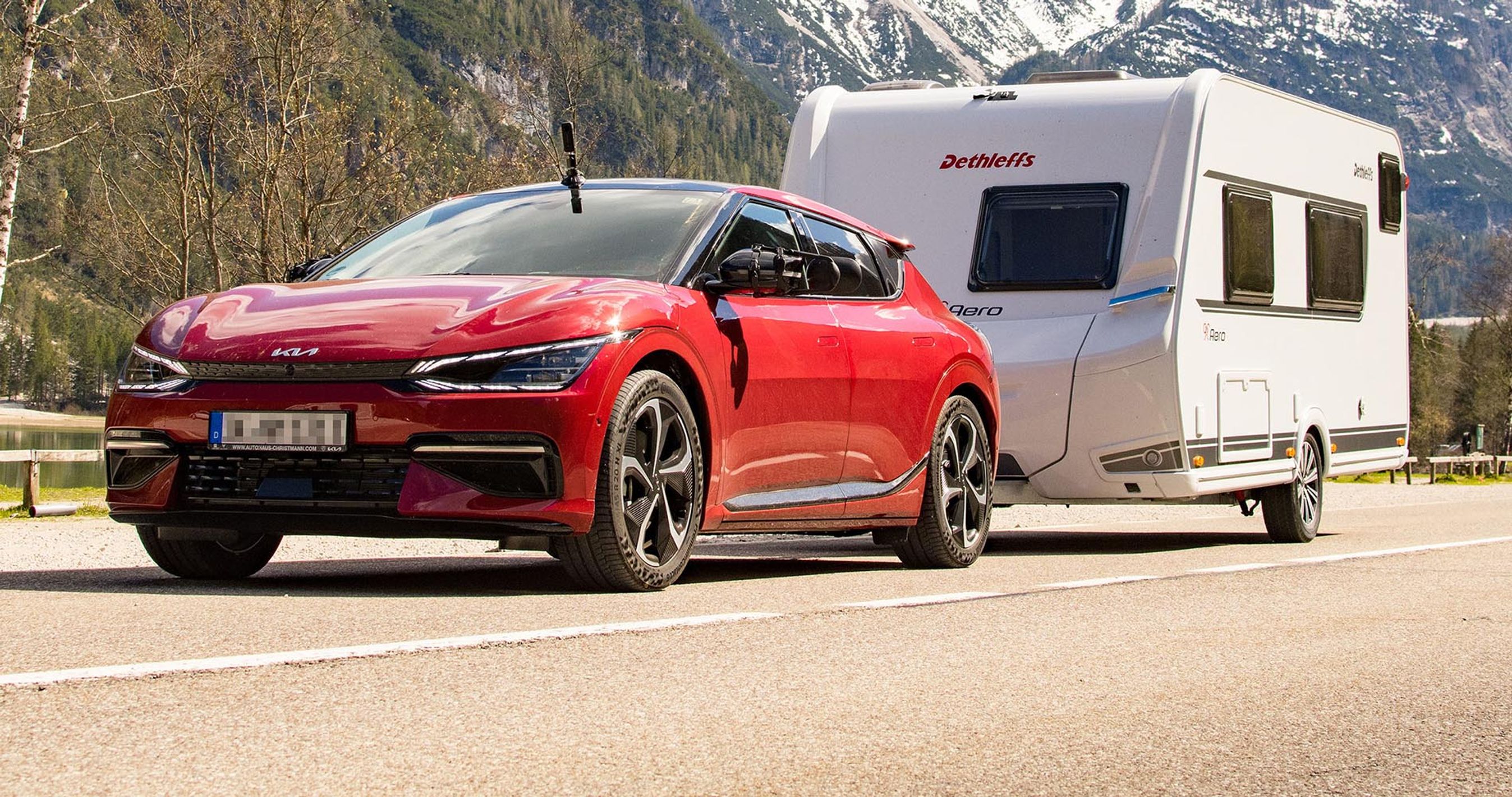 Kia EV6 trækker en campingvogn i bjergene. 