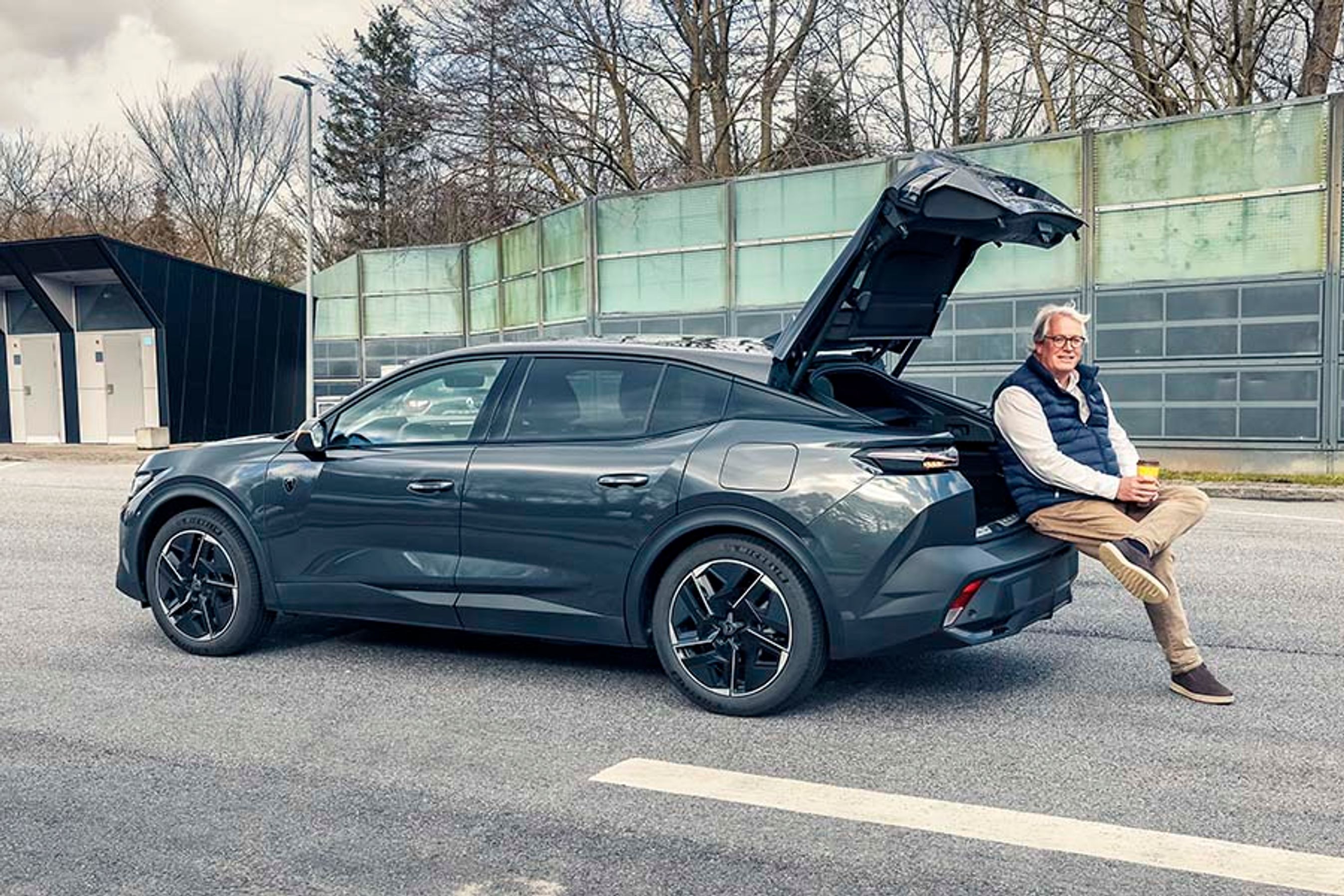 Peugeot 408 lægger op til mange kilometer bag rattet. Den kører godt, og er komfortabel at sidde i over lang tid. Men engang i mellem skal man lige ud at strække ben og måske som her nyde en kop kaffe fra bagagerummet.