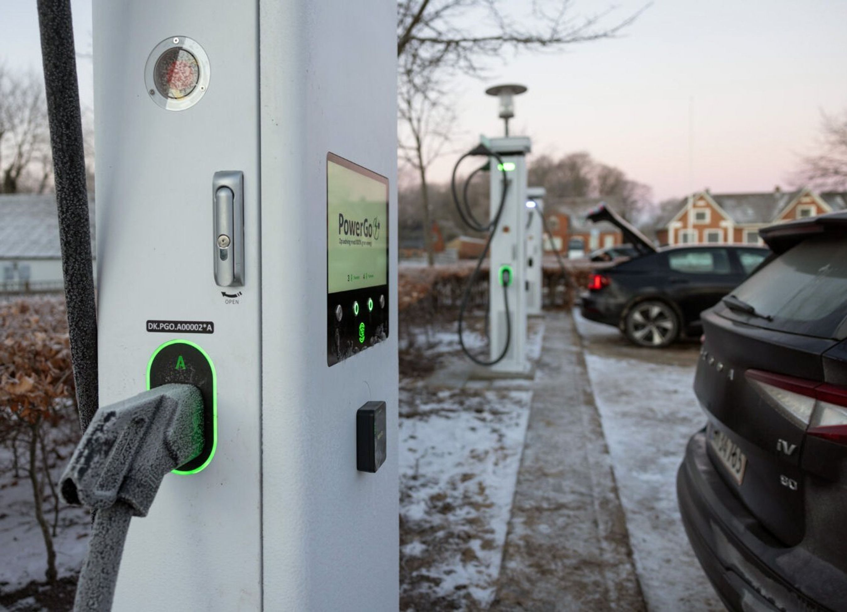 Ladestander i forgrunden, elbiler i baggrunden.