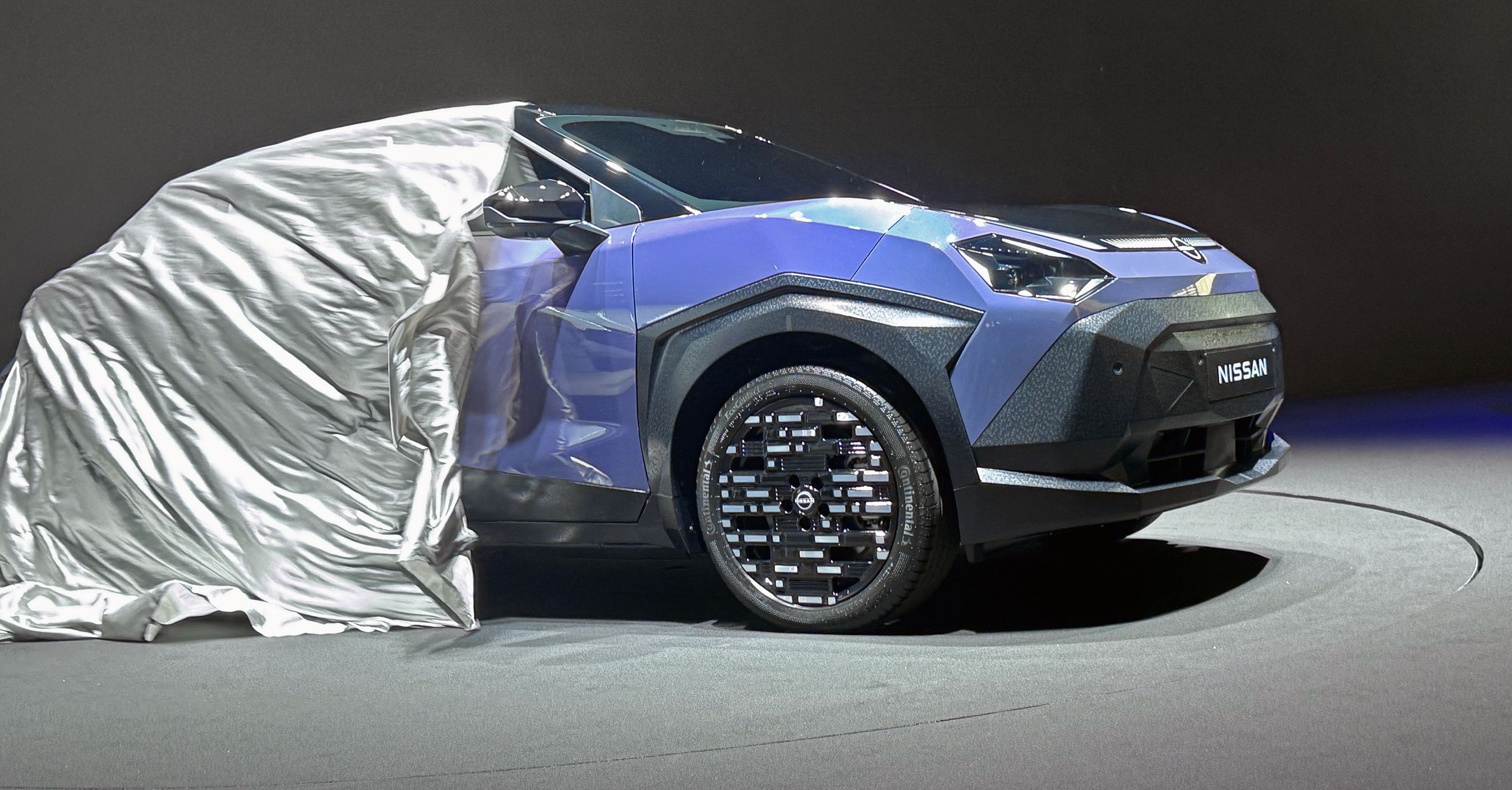 Klæde trækkes af blå bil.