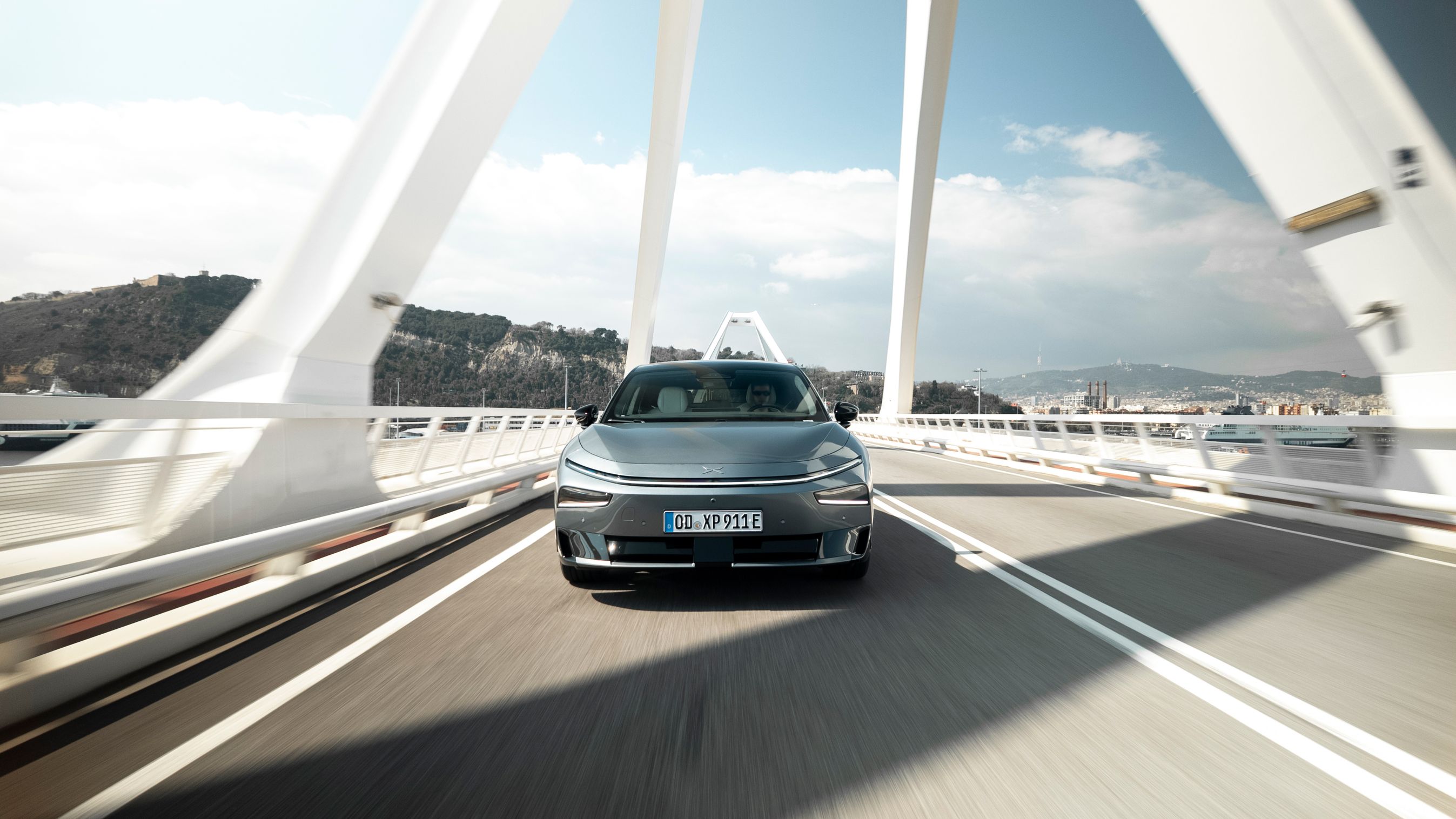 Xpeng P7+ set forfra, mens den kører over bro