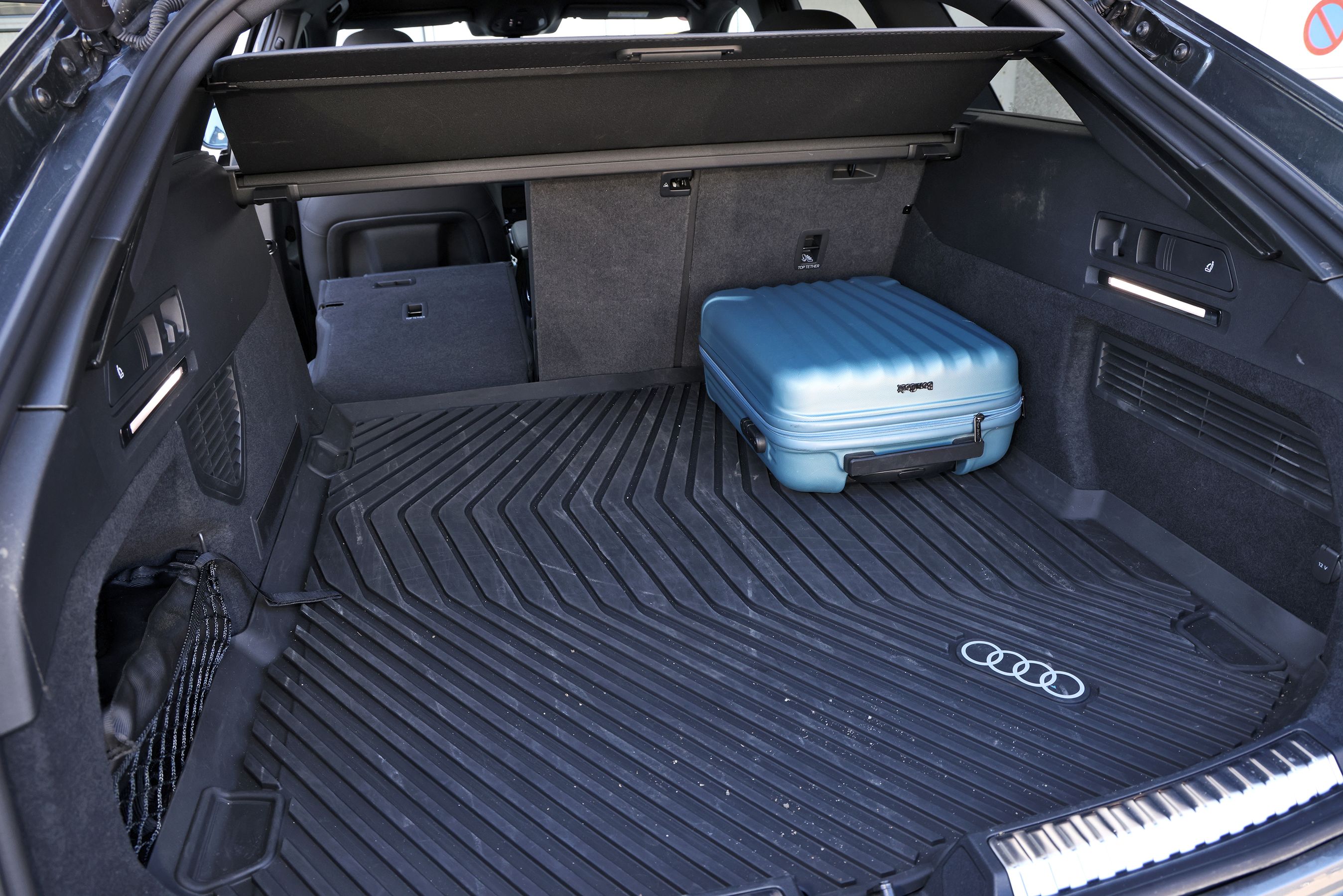 Bagagerum med blå kuffert i en Audi A6 Avant
