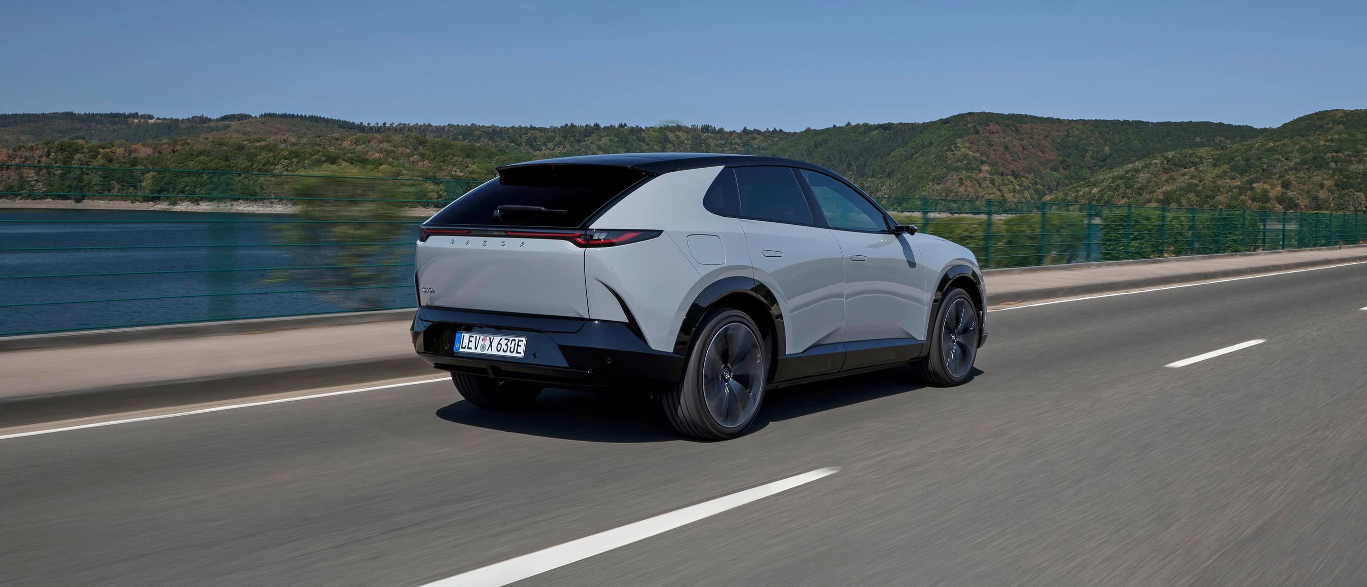 Lys Mazda CX-6e kørende set bagfra.