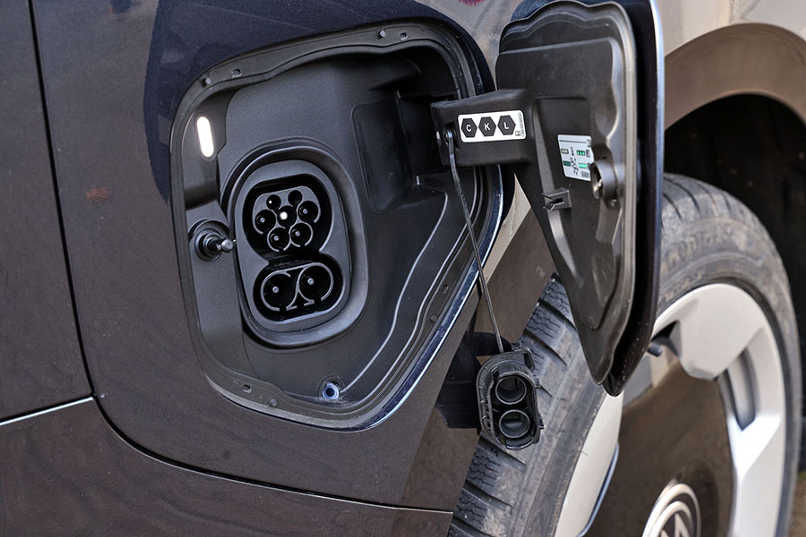 VW ID. Buzz med det store batteri (86 kWh netto) kan oplades hjemme med tre faser og 11 kW, og på farten kan bilen DC-lades med op til 200 kW. Ladestikket er placeret ved højre baghjul.