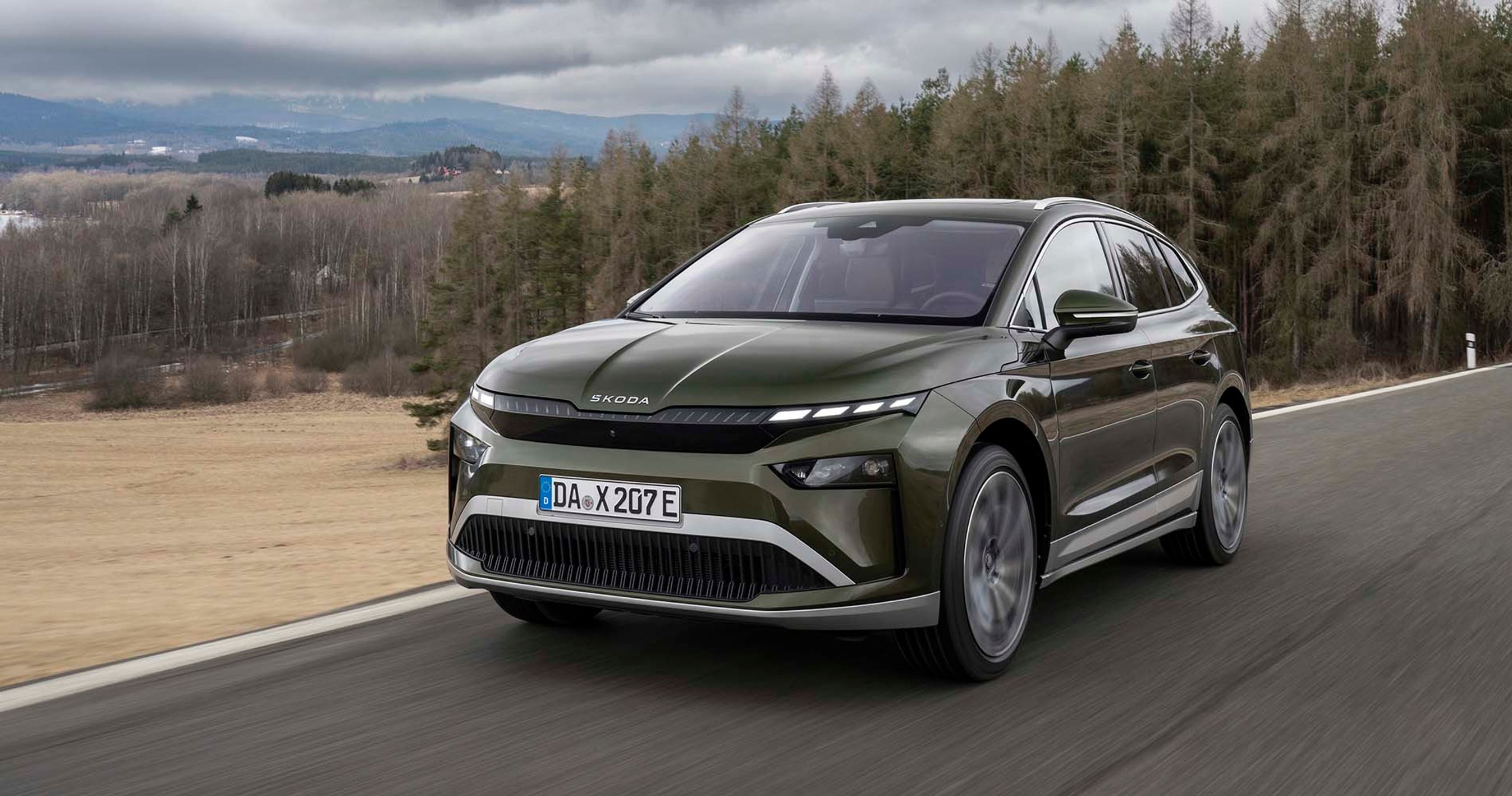 Skoda Enyaq set forfra, mens den kører på vej med træer i baggrunden