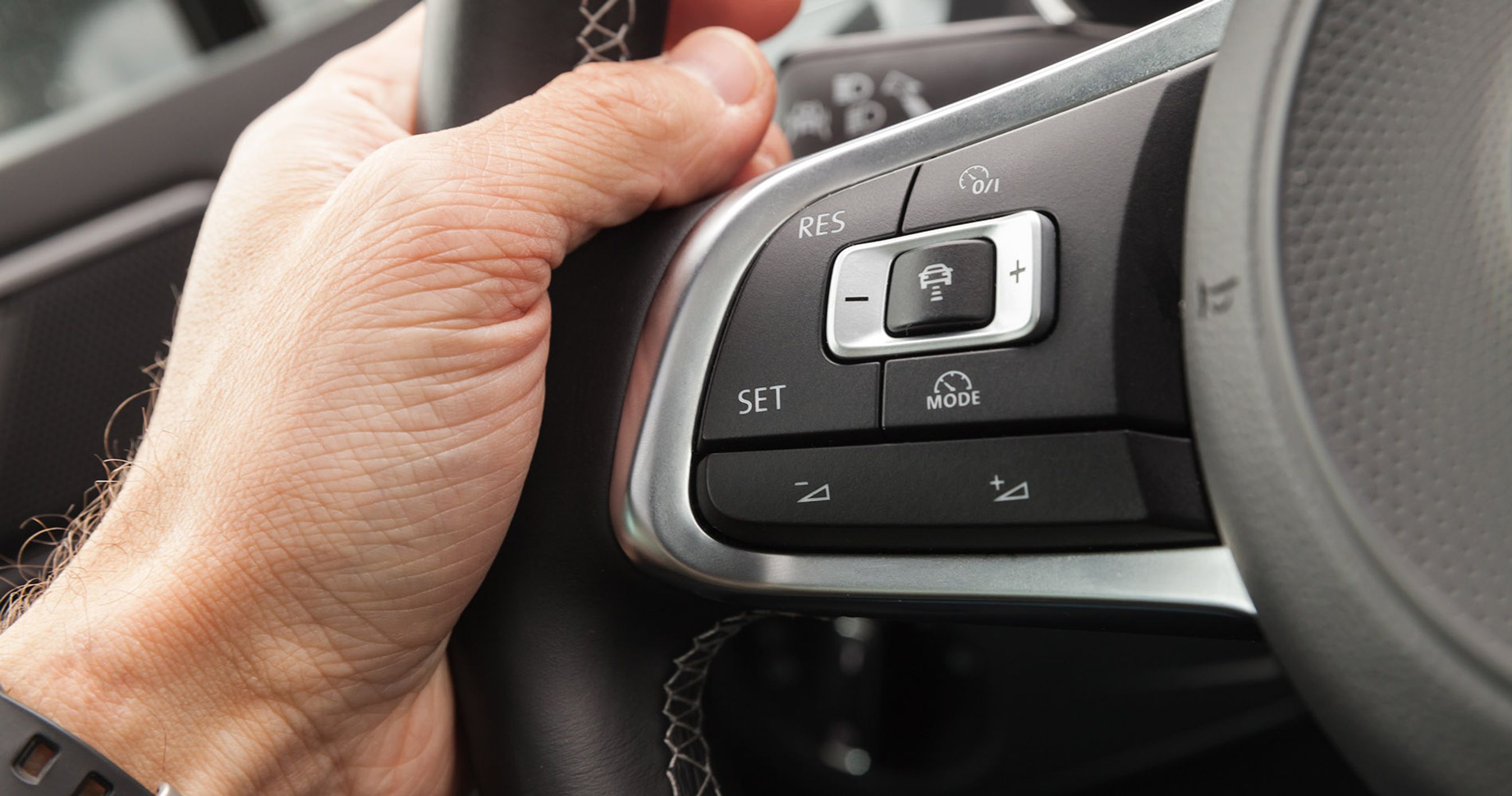 Nærbillede af rattet på en bil, hvor det er muligt at indstille den adaptive fartpilot.