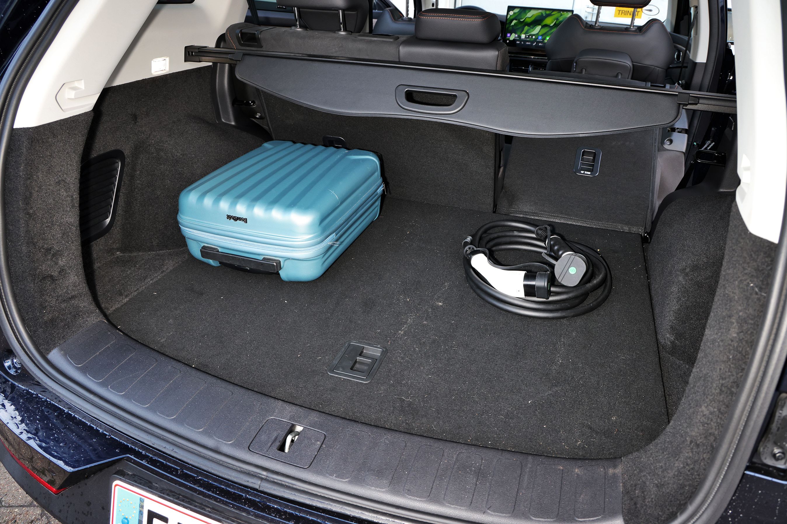 Bagagerum med blå kuffert og ladekabel i en Skyworth K