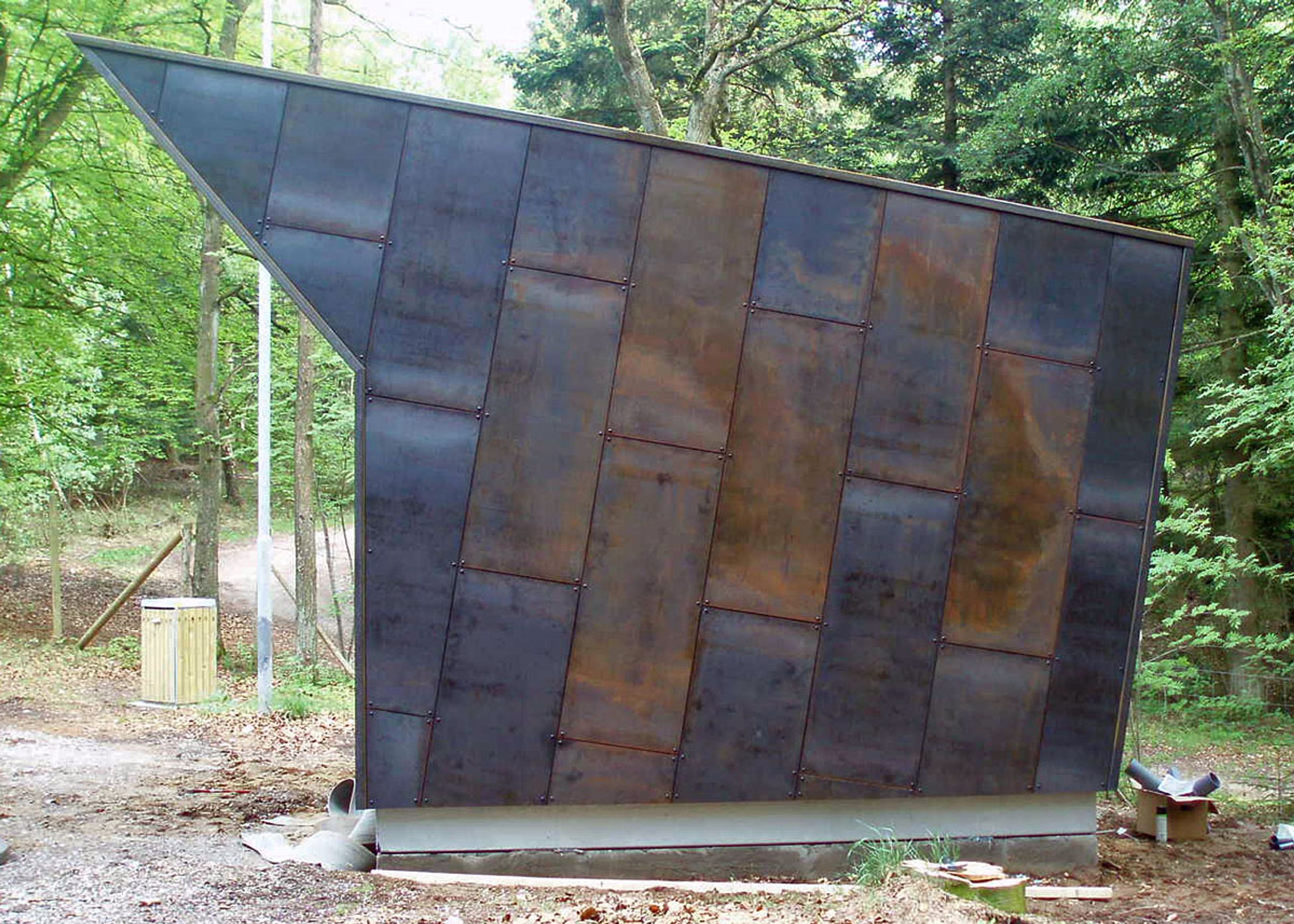 Toiletbygningen har en rustik fremtoning, men der er også ret store vinduer.