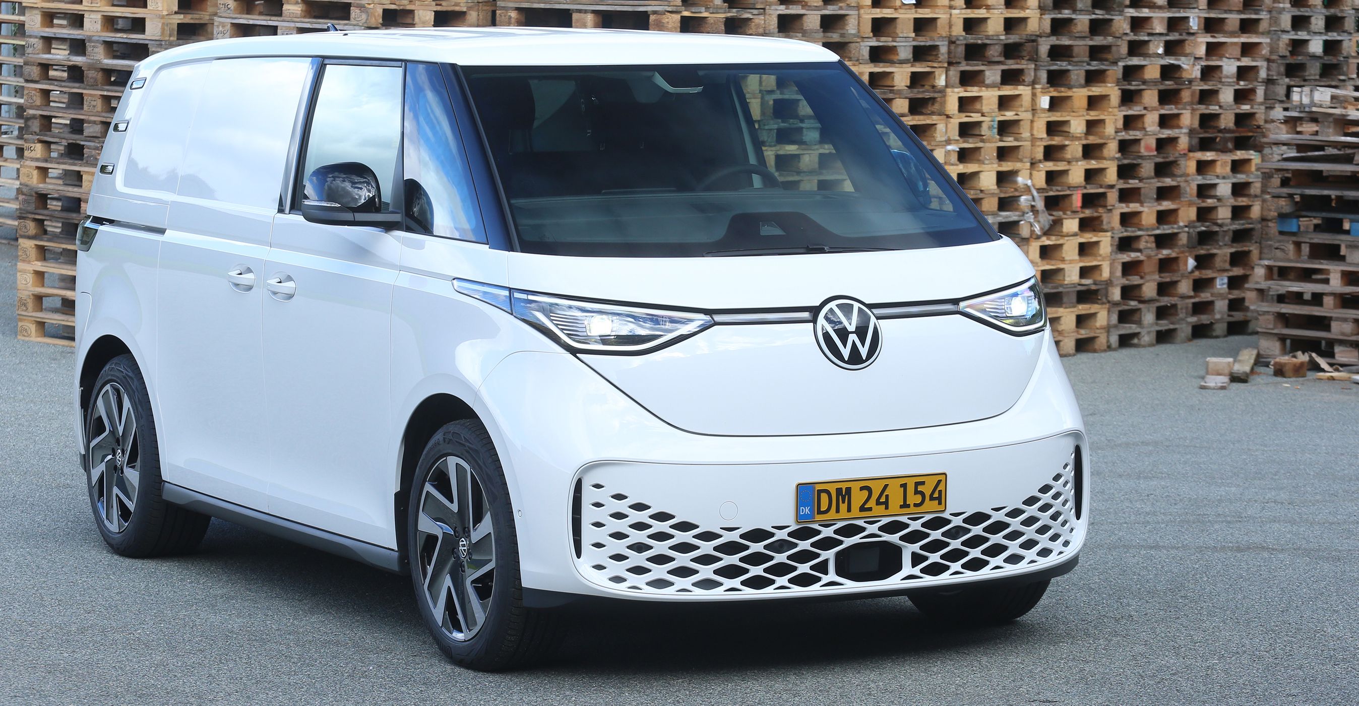 Hvid VW Buzz Cargo foran paller.