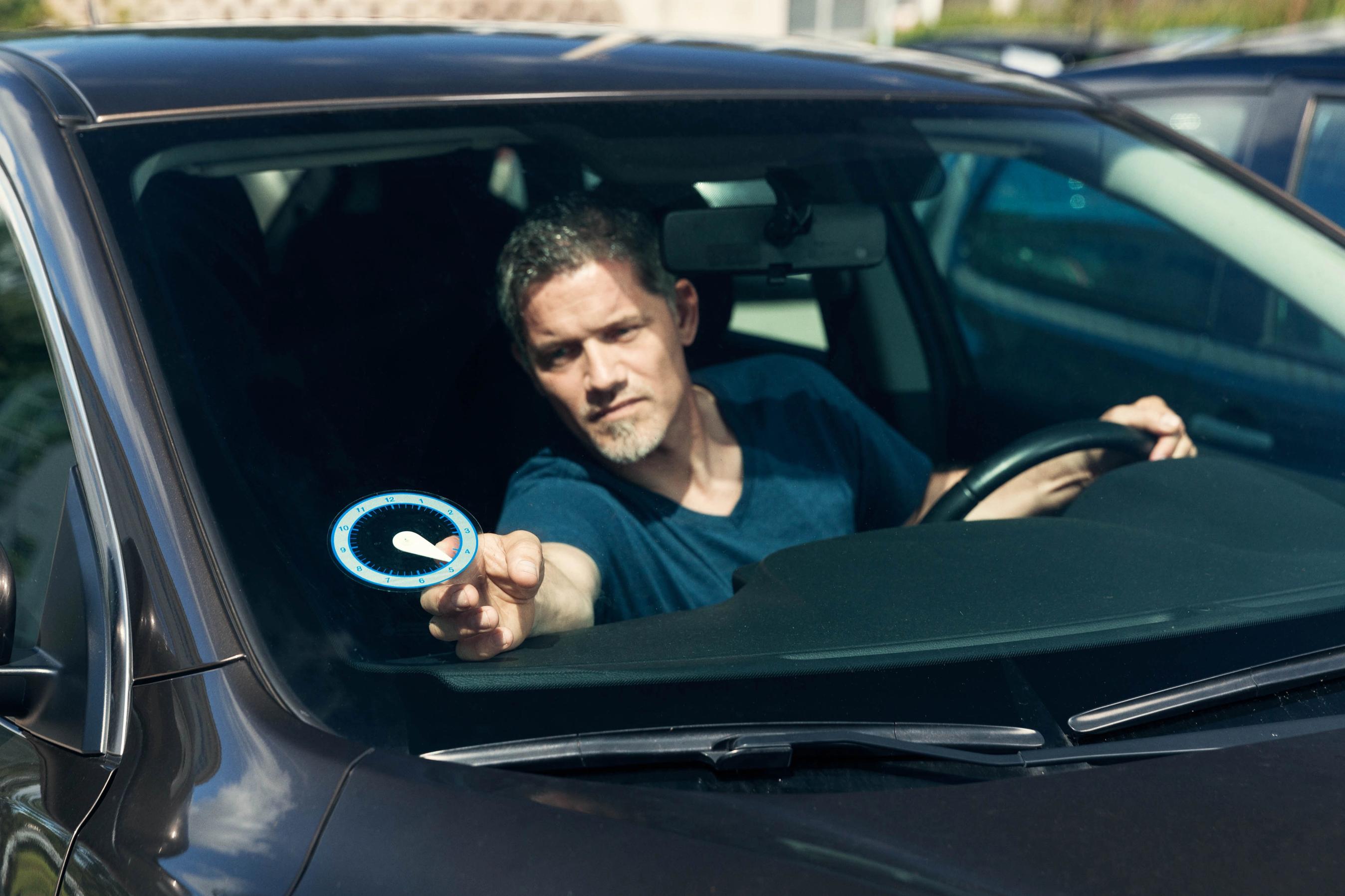 Mand indstiller p-skive i bil.