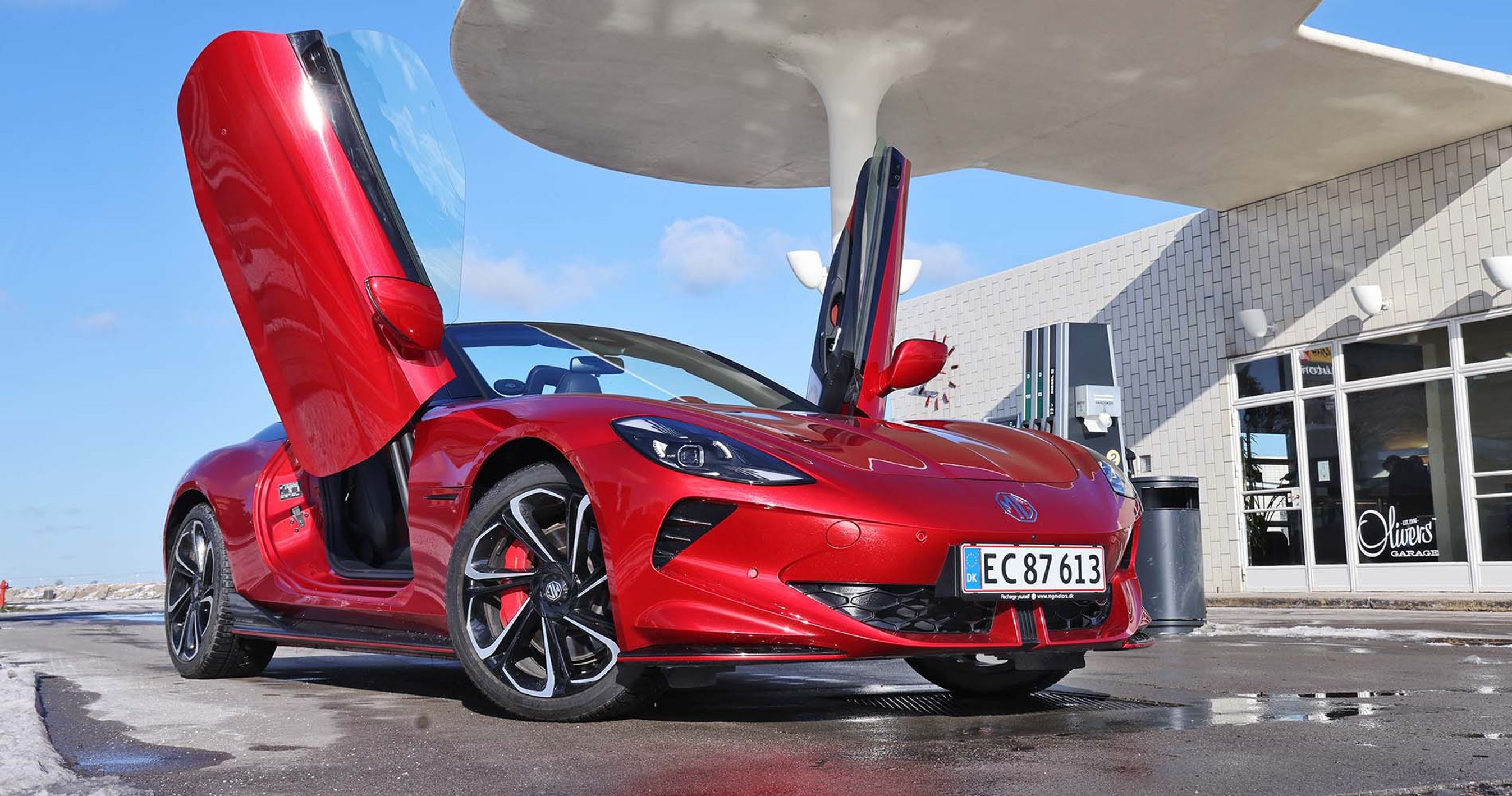 MG Cyberster med åbne døre holder foran legendarisk tankstation