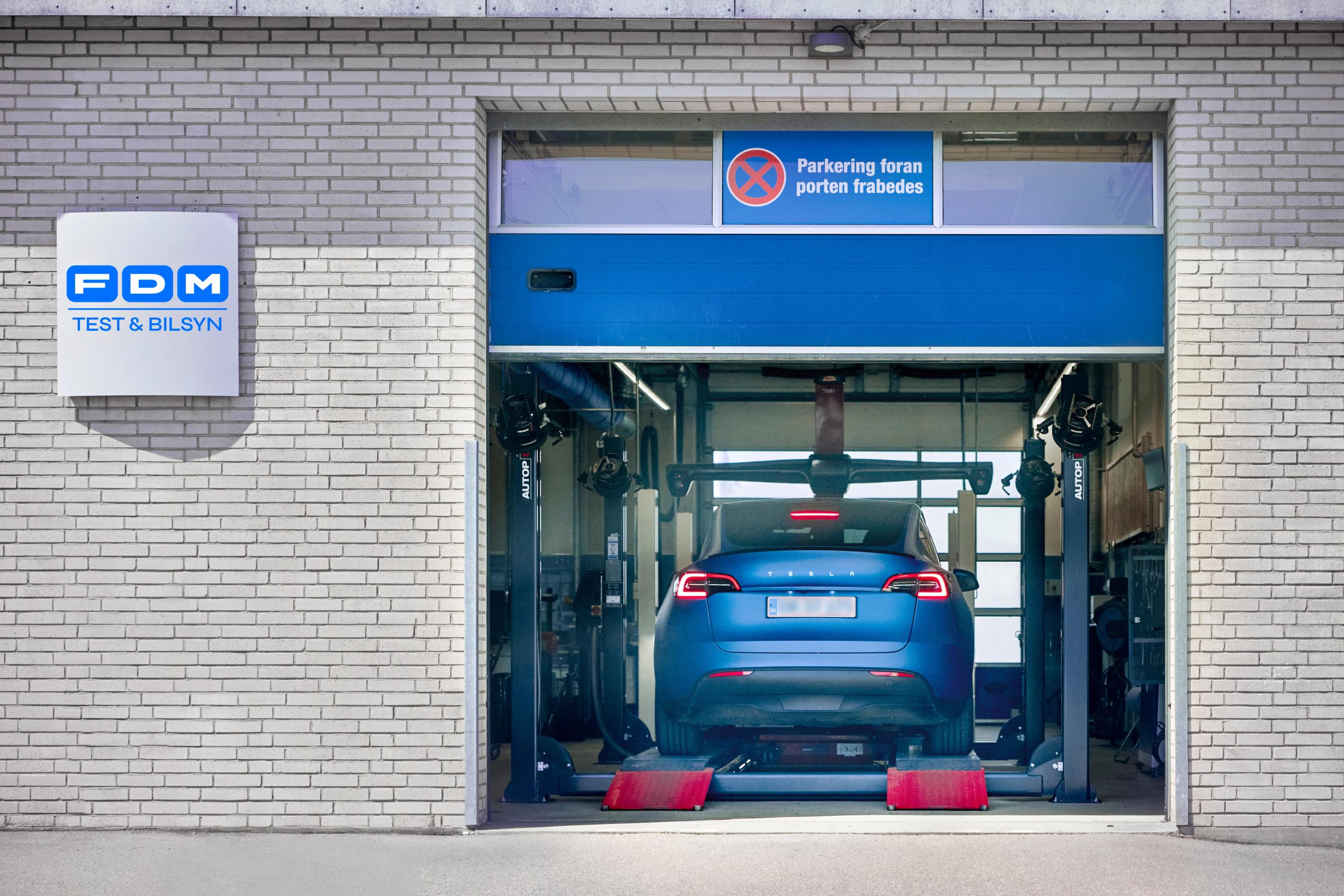 Bil kører ind i Test og Bilsyn hallen for at få tjekket bilen - biltest fra FDM Test og Bilsyn