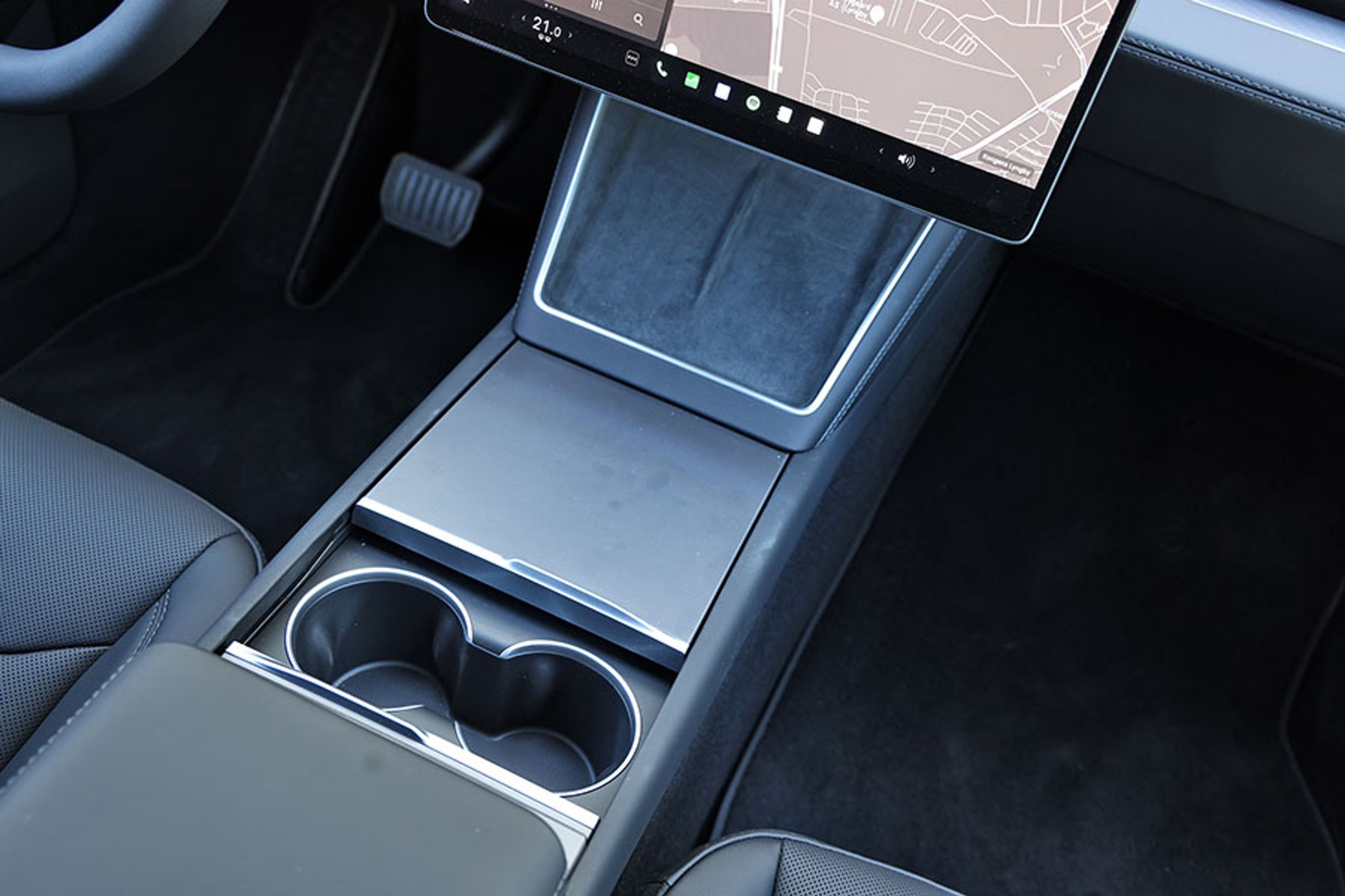 Fralægningsplads er og har altid været en stor styrke ved Tesla Model Y. Der er to trådløse ladepladser til mobiltelefoner, to gode kopholdere, og så er der et stort opbevaringsrum mellem dem samt under armlænet.