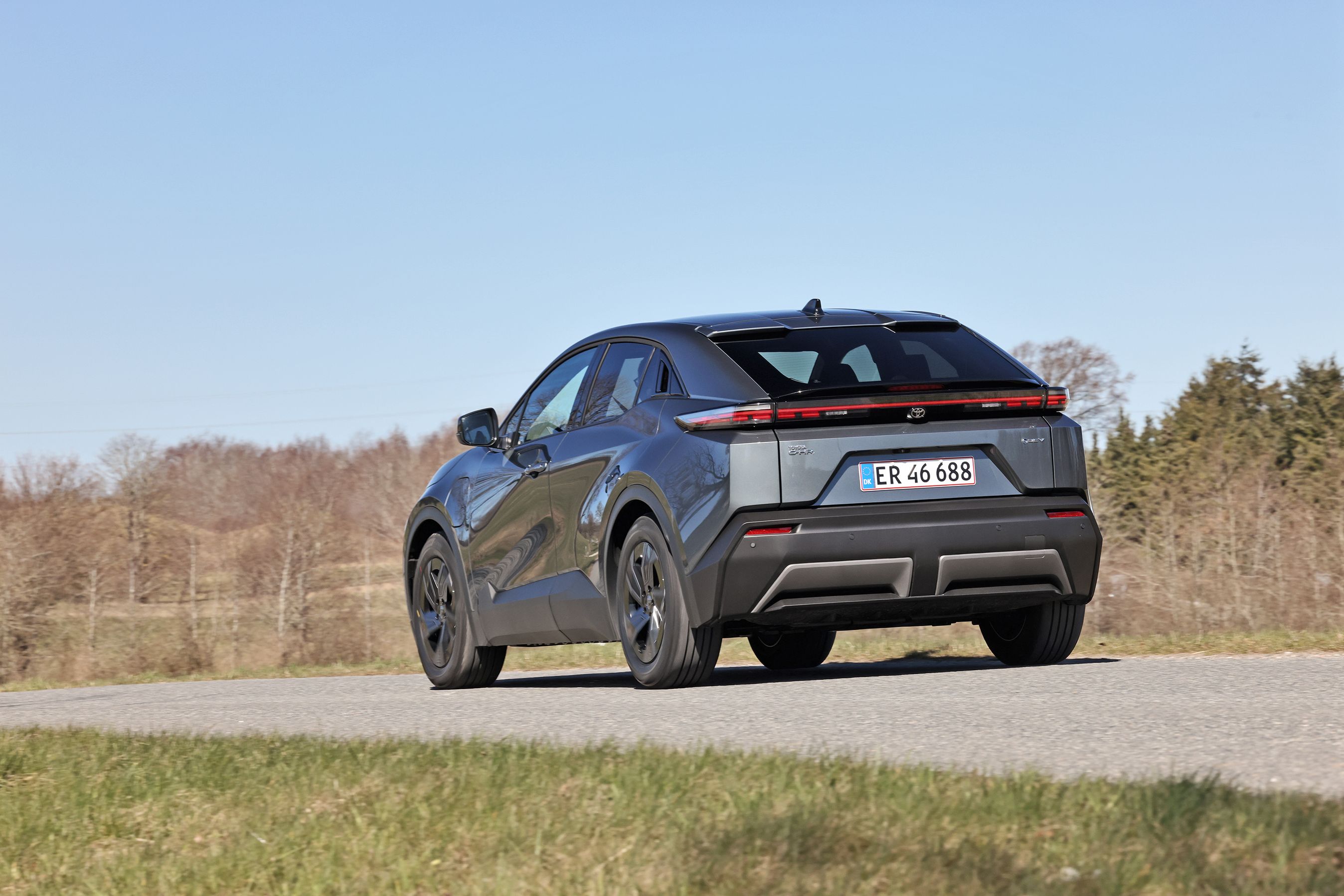 Toyota C-HR+ set bagfra, mens den kører på landevej