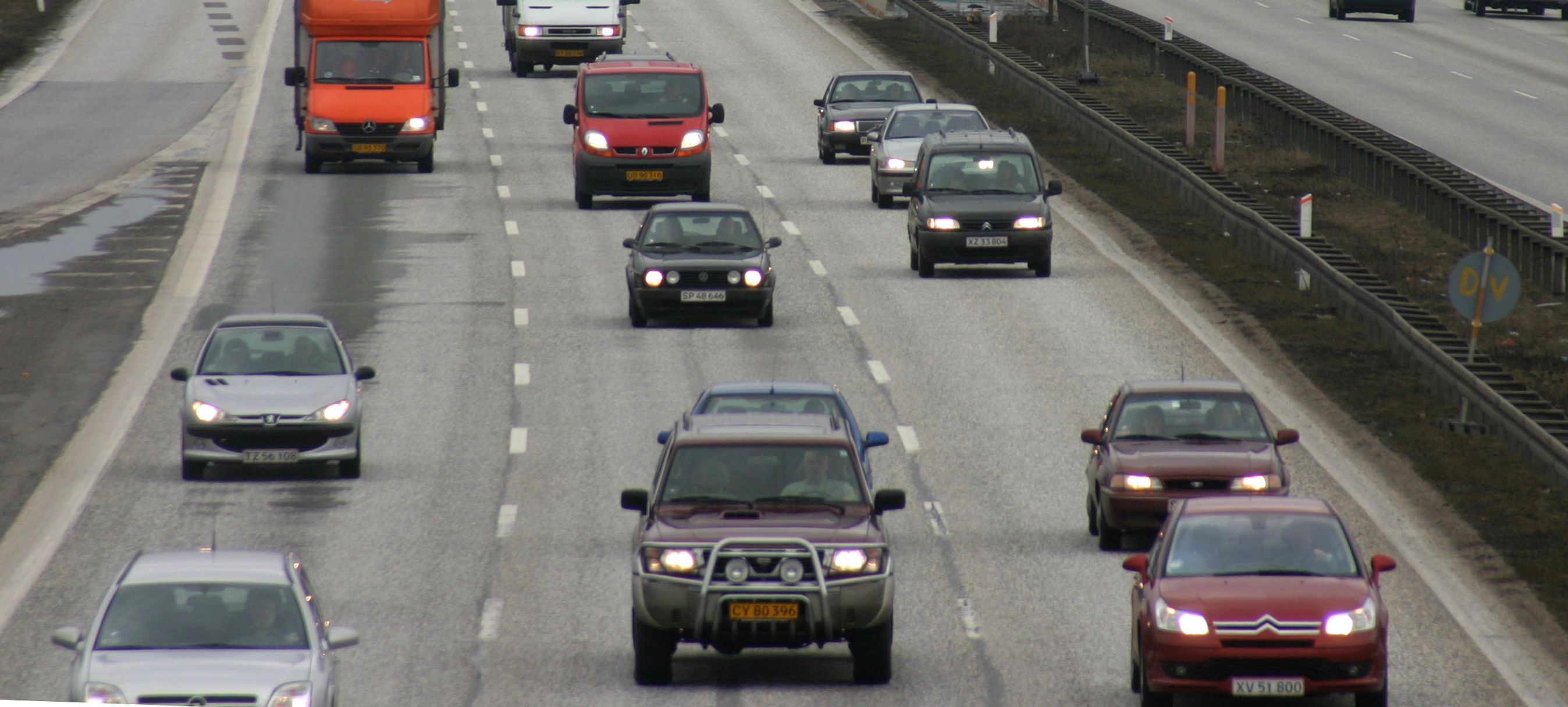 Ældre biler kørende på motorvej. 
