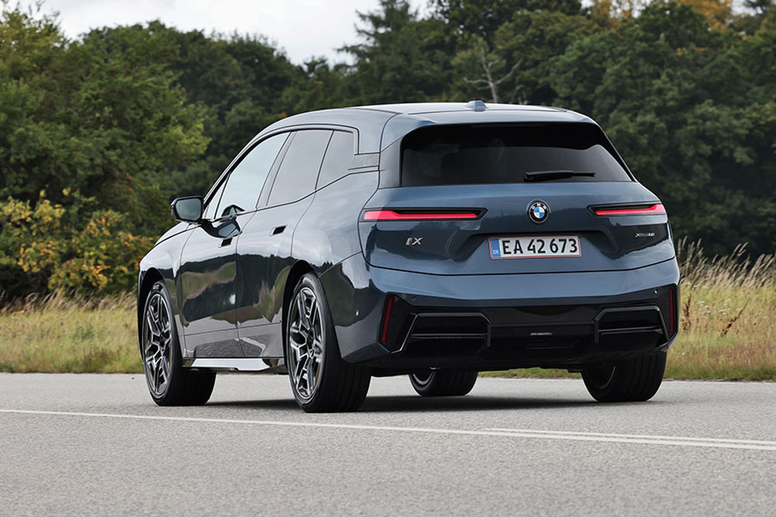 BMW iX set bagfra, mens den kører på en landevej