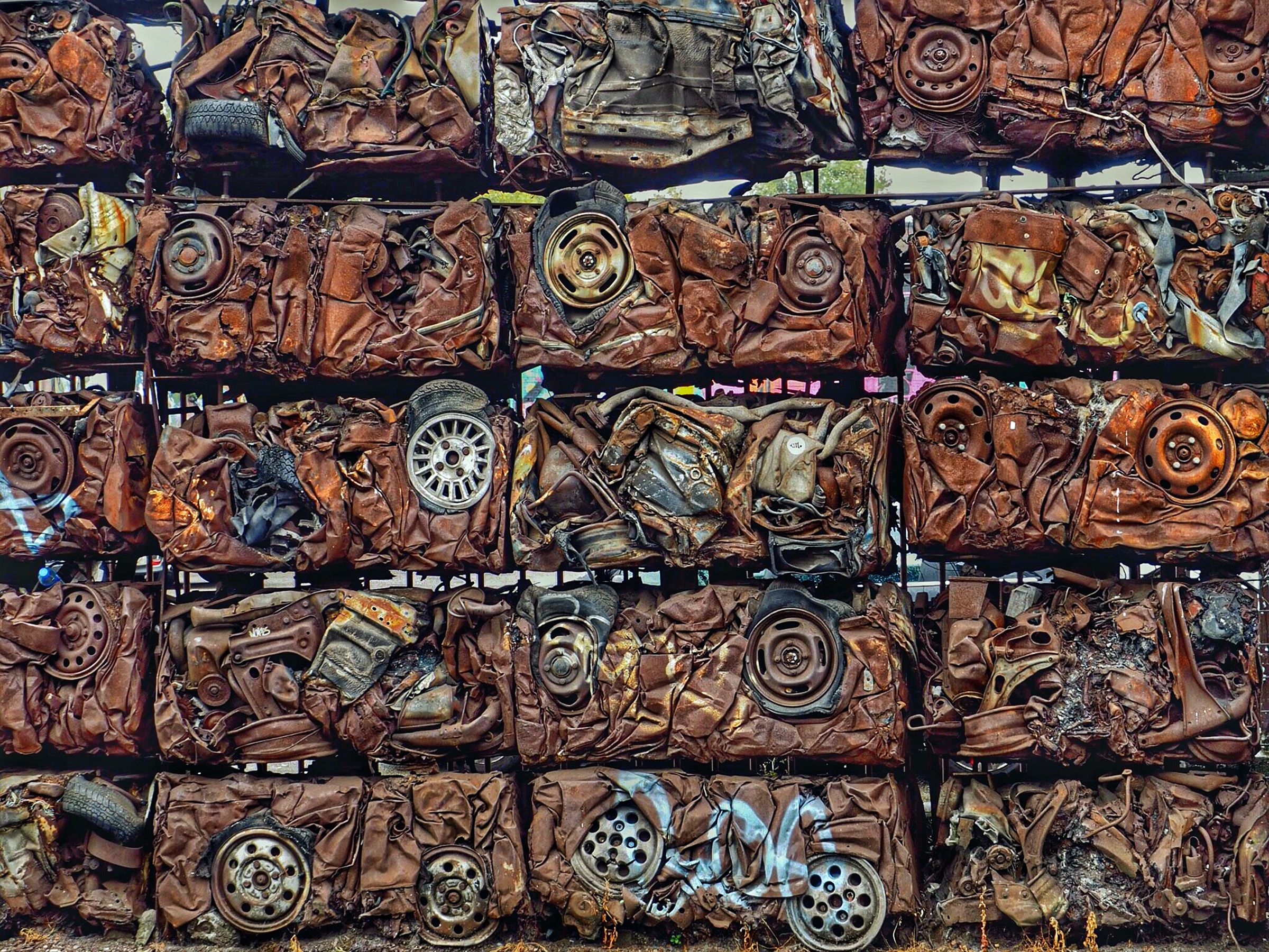 Skrotbiler der er presset sammen til firekanter stablet oven på hinanden