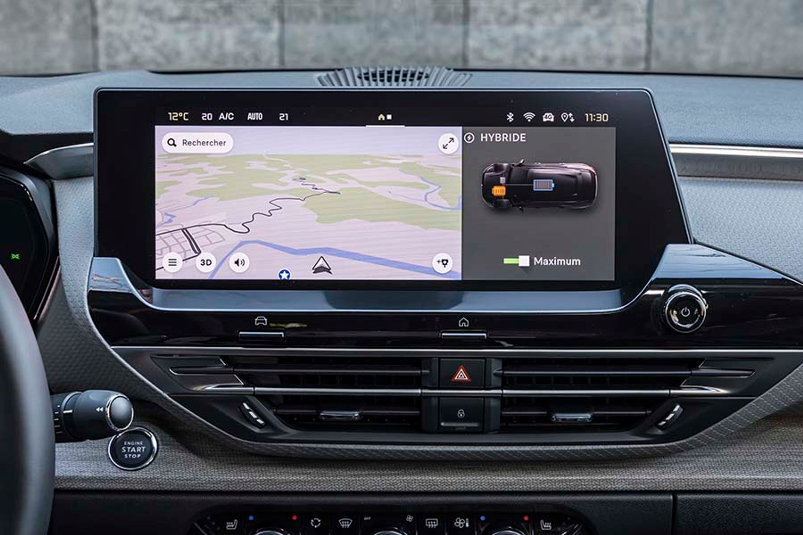 Det er et helt nyt styresystem, der ligger bag funktionerne i skærmen. Alle menuer er på dansk, men bilen forstår ikke dansk tale. Man kan opdele skærmen i to felter, så man som her både kan se på navigationsanlæg og oplysninger om strømmen samtidig. Bemærk den nyttige Hjem-knap.