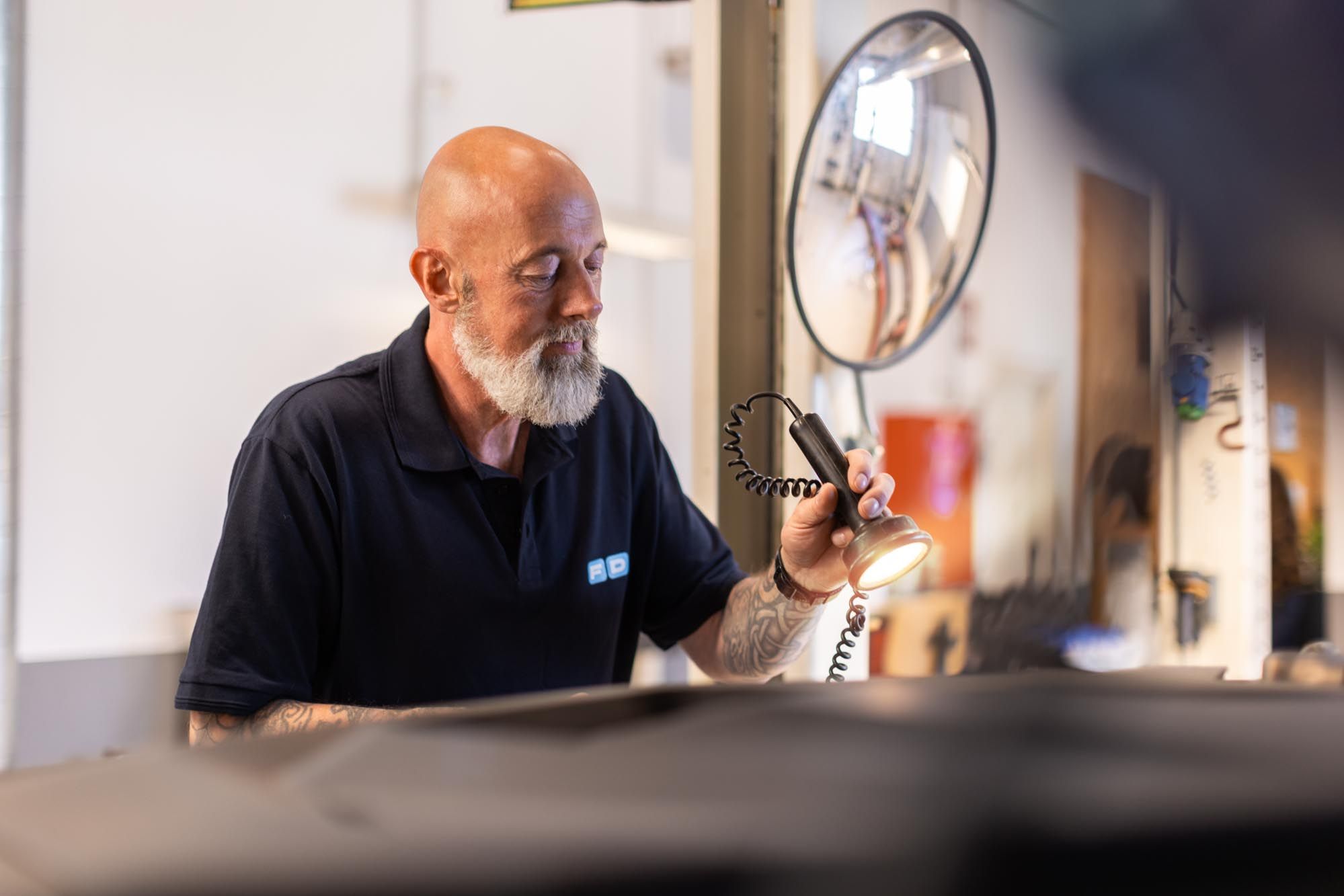 FDM medarbejder lyser i motorrum på bil i testcenteret