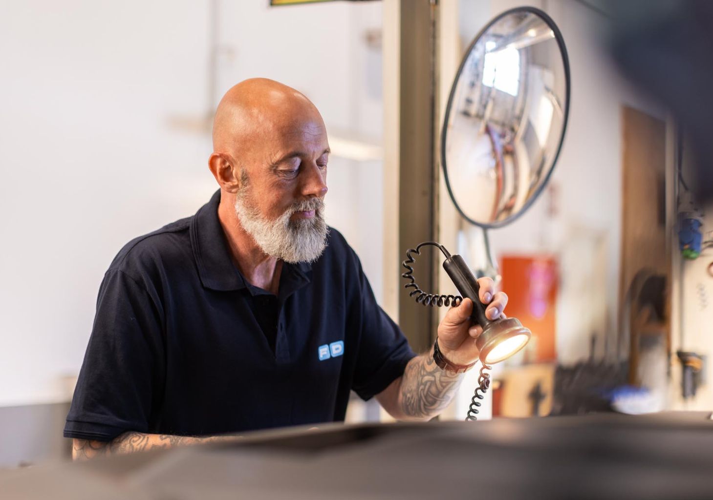 FDM medarbejder lyser i motorrum på bil i testcenteret